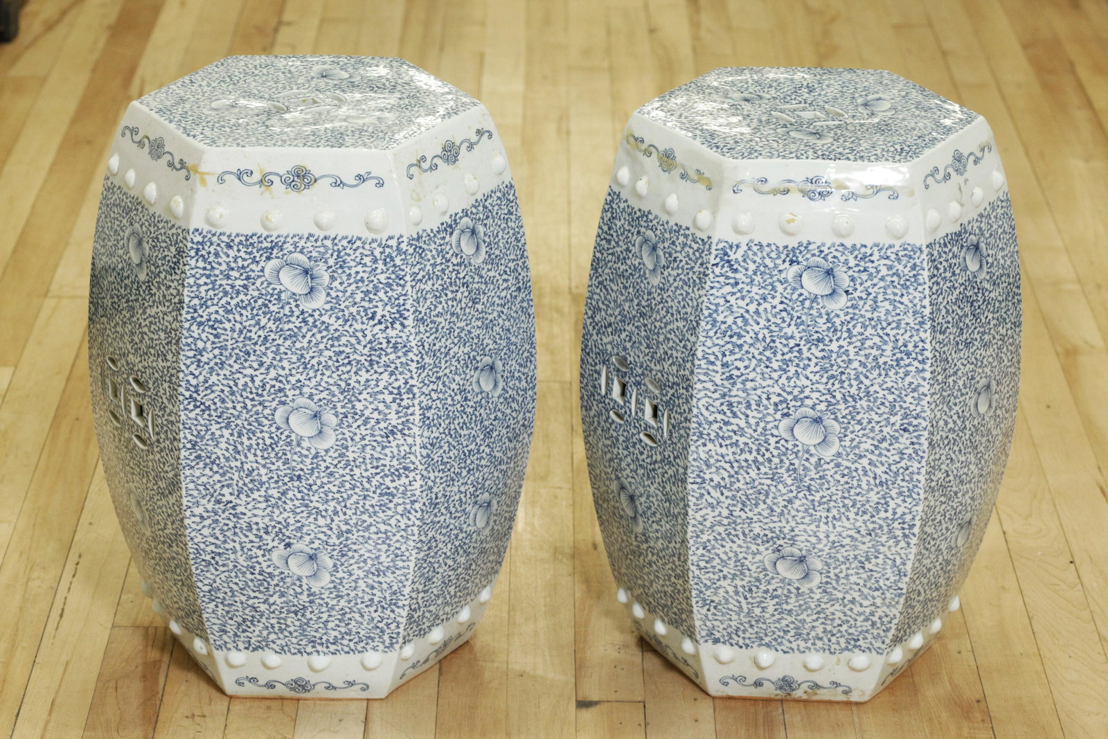 Pair Chinese Blue & White Porcelain Garden Seats: Pair Chinese Blue & White Porcelain Hexagonal Garden Seats with an over-all design of flowers and scrolling branches in underglaze blue; molded with bosses imitating nail heads and a pair of "Cash Coi