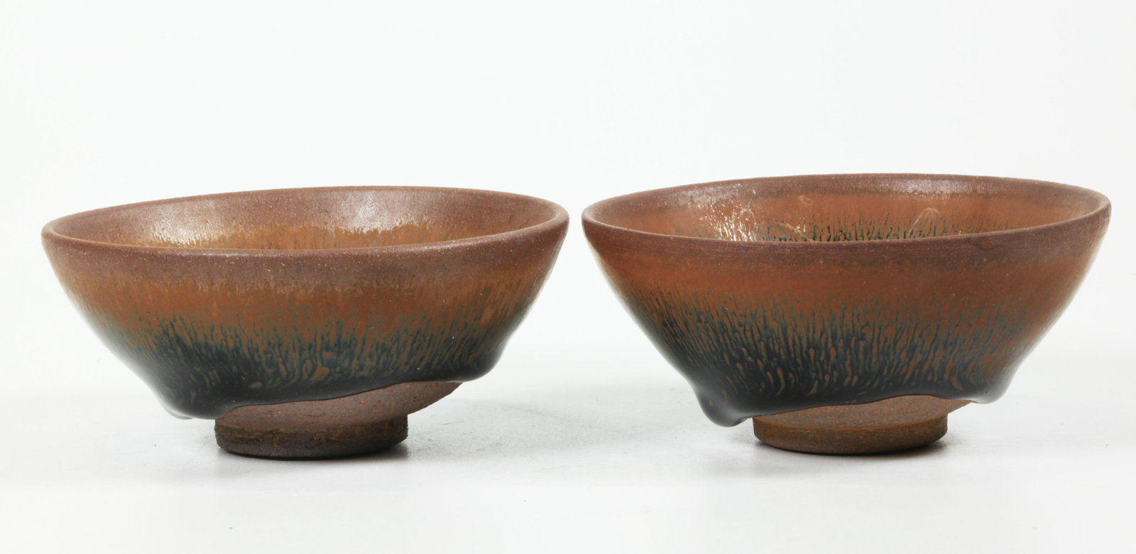 2 Chinese Hare's Fur Henan Porcelain Tea Bowls: 2 Chinese Hare's Fur Henan Porcelain Tea Bowls, the glaze ending in an even roll above the unglazed foot rim and base. Diameter 3 1/2 inches (9 cm.).