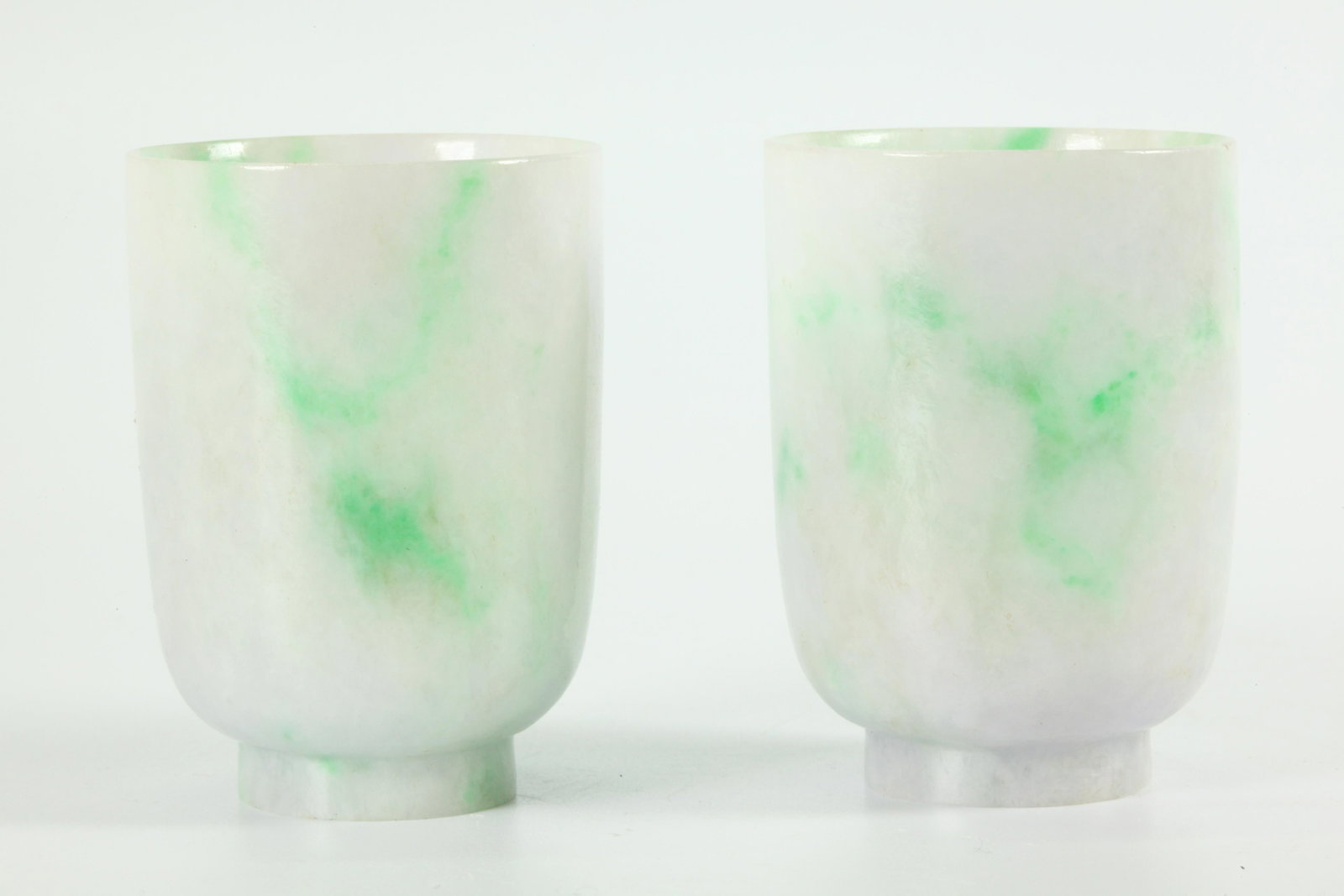 Pair of Chinese Apple Green Streak Jadeite Teacups: Pair of Chinese Apple Green Streaked warm white Jadeite Teacups. Height 2 3/4 inches (6.3 cm.).