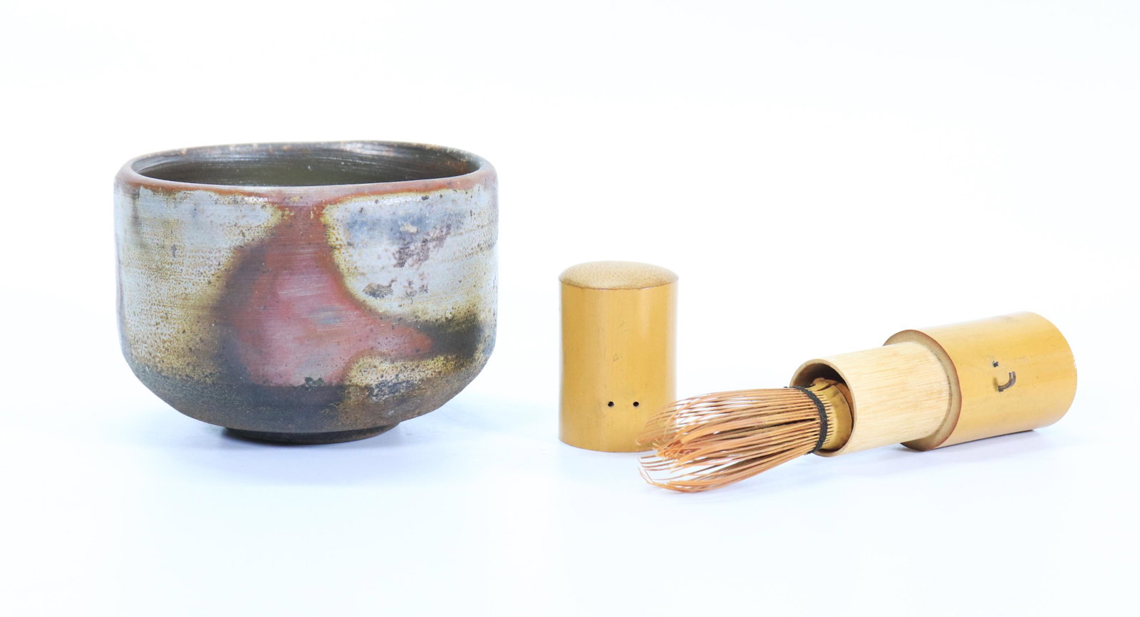 Japanese Tea Ceremony Bamboo Whisk; Bizen Bowl: Japanese Tea Ceremony Bamboo Whisk in a 2 part bamboo protective case; together with a Bizen Tea Bowl with incised mark at base. Length of bamboo whisk 3 1/2 inches (8.9 cm.). Diameter of tea bowl 4 3