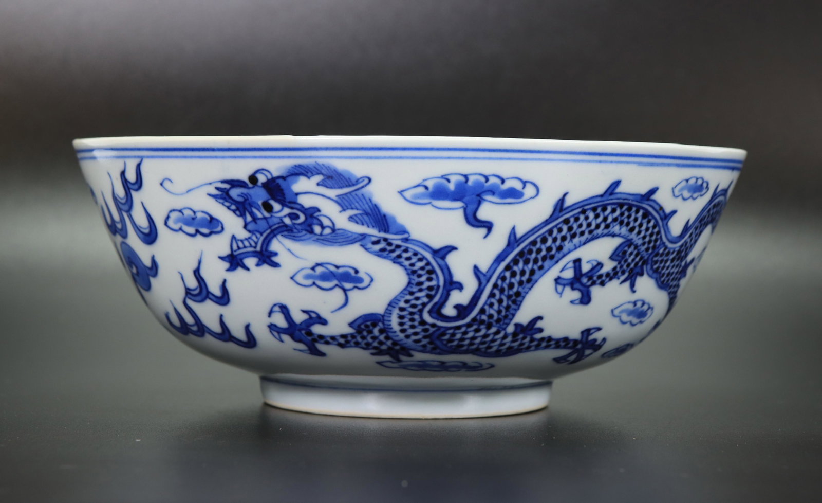 Chinese 19th C Blue & White Porcelain Dragon Bowl: Chinese 19th C Blue & White Porcelain Dragon Bowl with 3 four-claw Dragons in Clouds and flames with Pearls and 8 Bats & Clouds to inside edge, the clear glazed base with a 4 character Kangxi mark in 