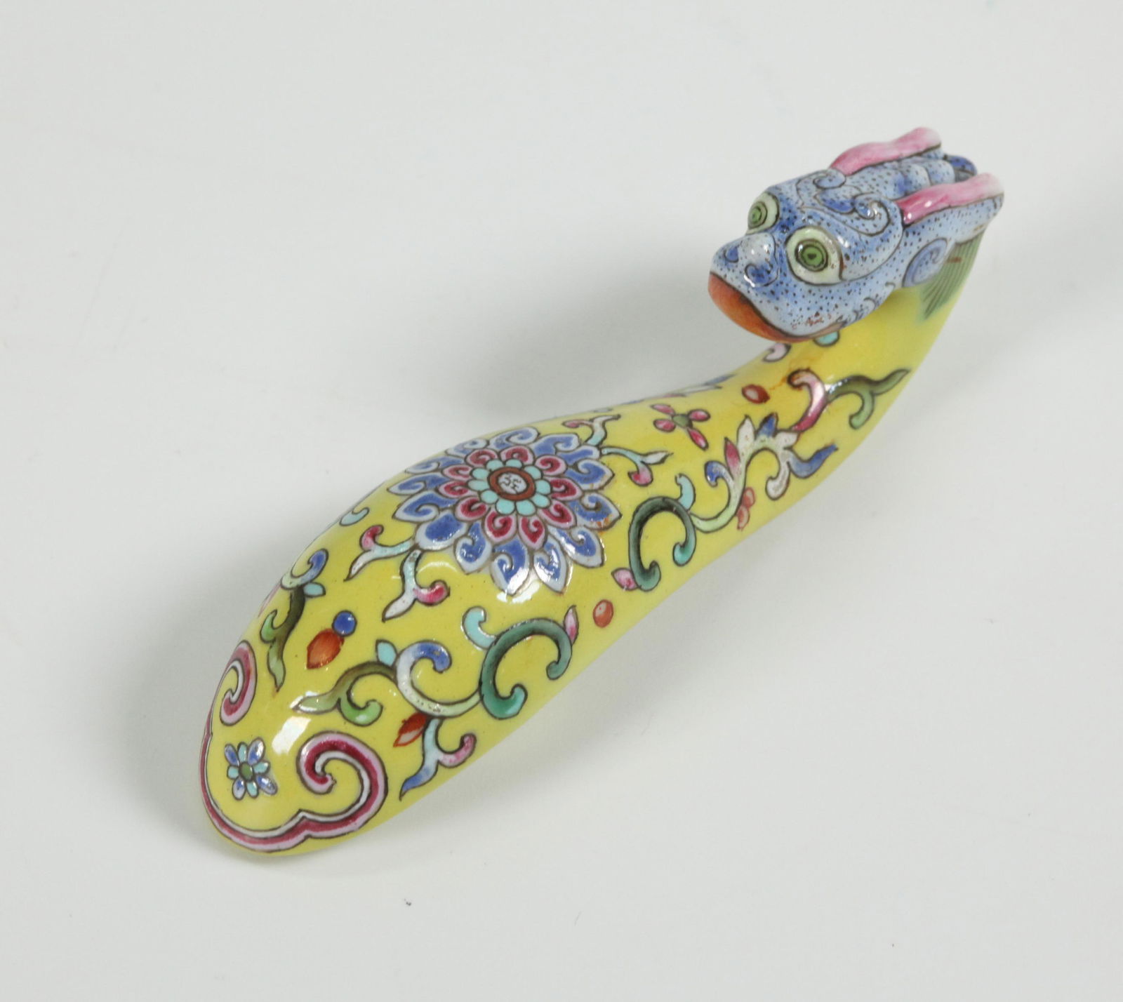 Chinese Famille Rose Porcelain Dragon Buckle: Chinese Famille Rose Porcelain Dragon Buckle with scrolling Lotus Flower on bright yellow ground, the head in spotted blue. Length 3 1/2 inches (8.8 cm.).