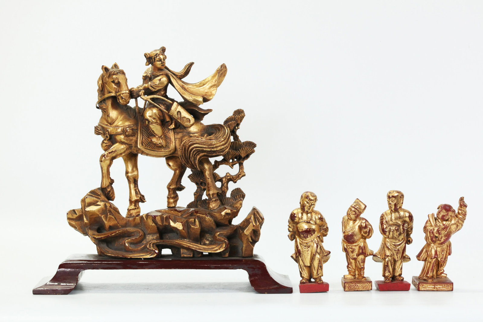 5 Chinese Gold Lacquer Wood Figures; Hua Mulan: 5 Chinese Gold Lacquer Wood Figures; the largest of Hua Mulan riding her horse to Battle with Bow, standing on rocks and clouds with a further brown lacquered wood stand; together with 4 small standin