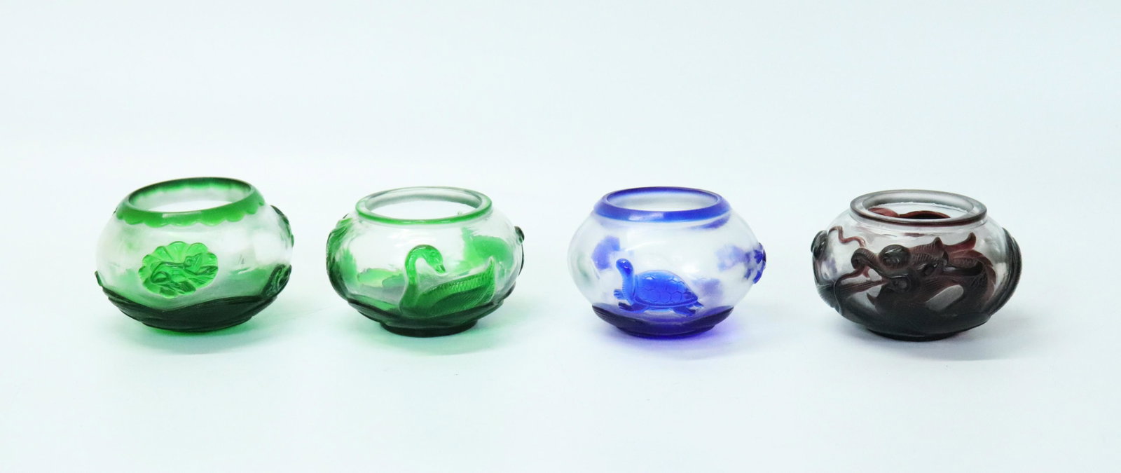 4 Chinese Peking Glass Color Overlay Brush Washers: 4 Chinese Peking Glass Color Overlay Brush Washers; 2 in transparent green over clear carved and polished with either geese or frogs, 1 in blue with frog & turtles, and 1 in amethyst with a Dragon in 