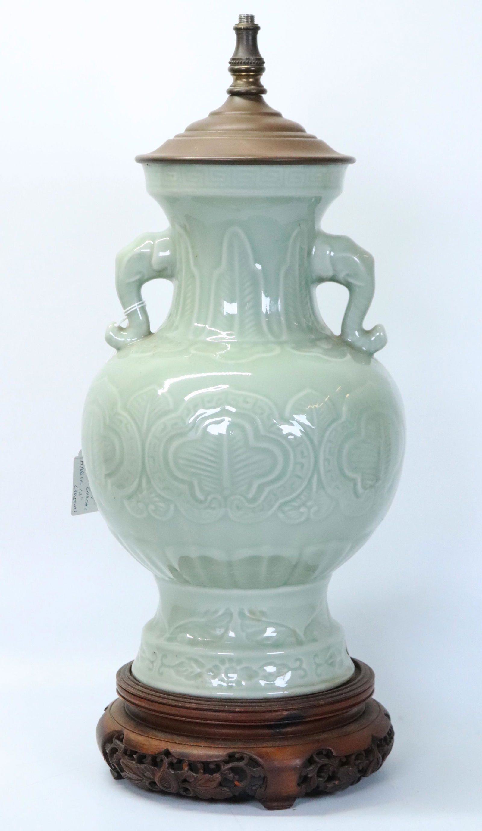 Chinese Carved & Molded Celadon Porcelain Vase: Chinese Carved & Molded Celadon Porcelain Vase with 2 Elephant Head handles, Ruyi Patterns and Leaves; on a well carved & pierced hard wood stand and metal cover as a lamp. Height of vase 12 inches (3