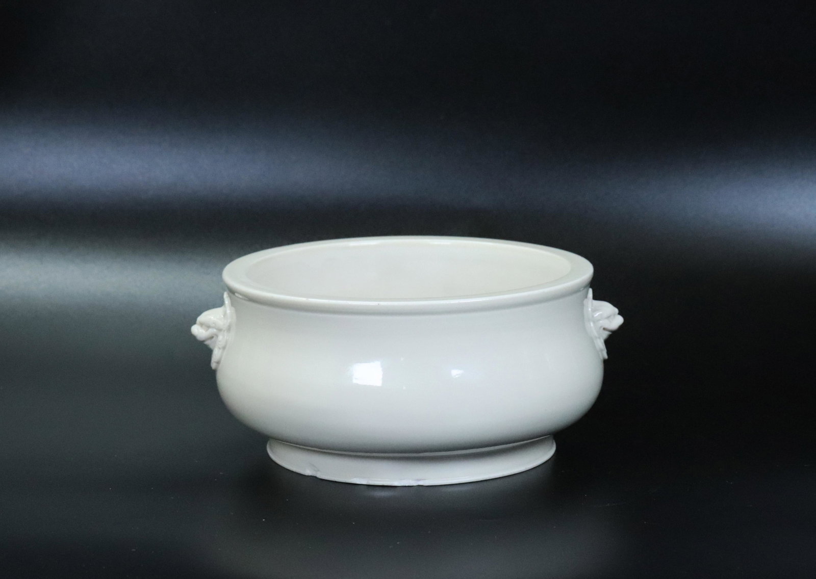 Lg Chinese Blanc de Chine Porcelain Incense Burner: Large Chinese Blanc de Chine cream colored Porcelain Incense Burner with molded Lion Head Handles to sides, the base and foot ring unglazed. Diameter at mouth 7 inches (17.8 cm.).