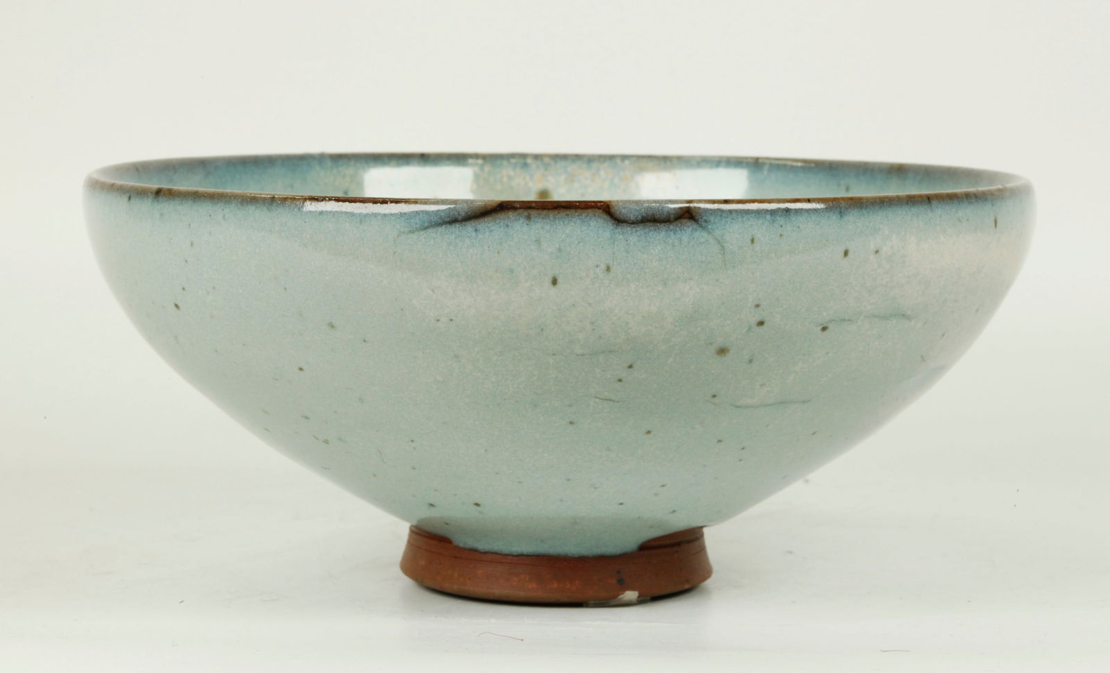 Chinese Pale Blue Junyao Porcelain Bowl: Chinese Pale Blue Junyao Porcelain Bowl with a splash of purple to side, the glaze thinning from the mouth to celadon, the foot ring and base unglazed and burned brown in the firing. Diameter 7 1/4 in