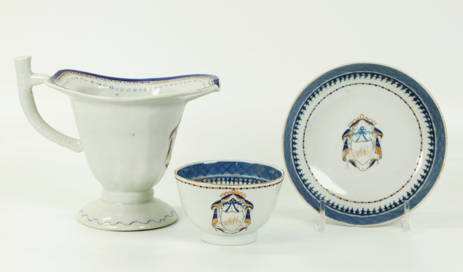 3 Chinese 18th C American Market Porcelains: 3 Chinese 18th Century American Market Porcelains, a Helmet Shaped Cream Pitcher with handle and a teacup without handle and matching saucer with high sides; each with pseudo armorial shields on ermin