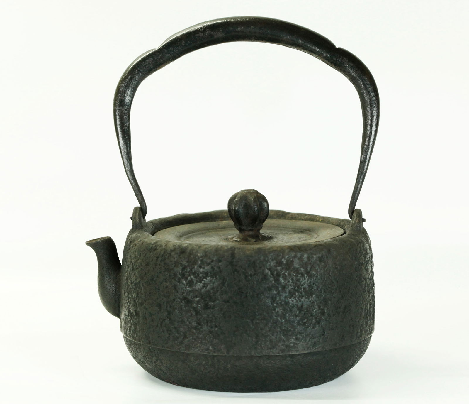 Japanese Cast Iron Tetsubin Teapot, Iron Lid: Japanese Cast Iron Tetsubin Teapot cast with a calligraphy inscription to side opposite the spout, with Iron Lid and flower bud finial, the overhead handle in shaped wrought iron with traces of silver