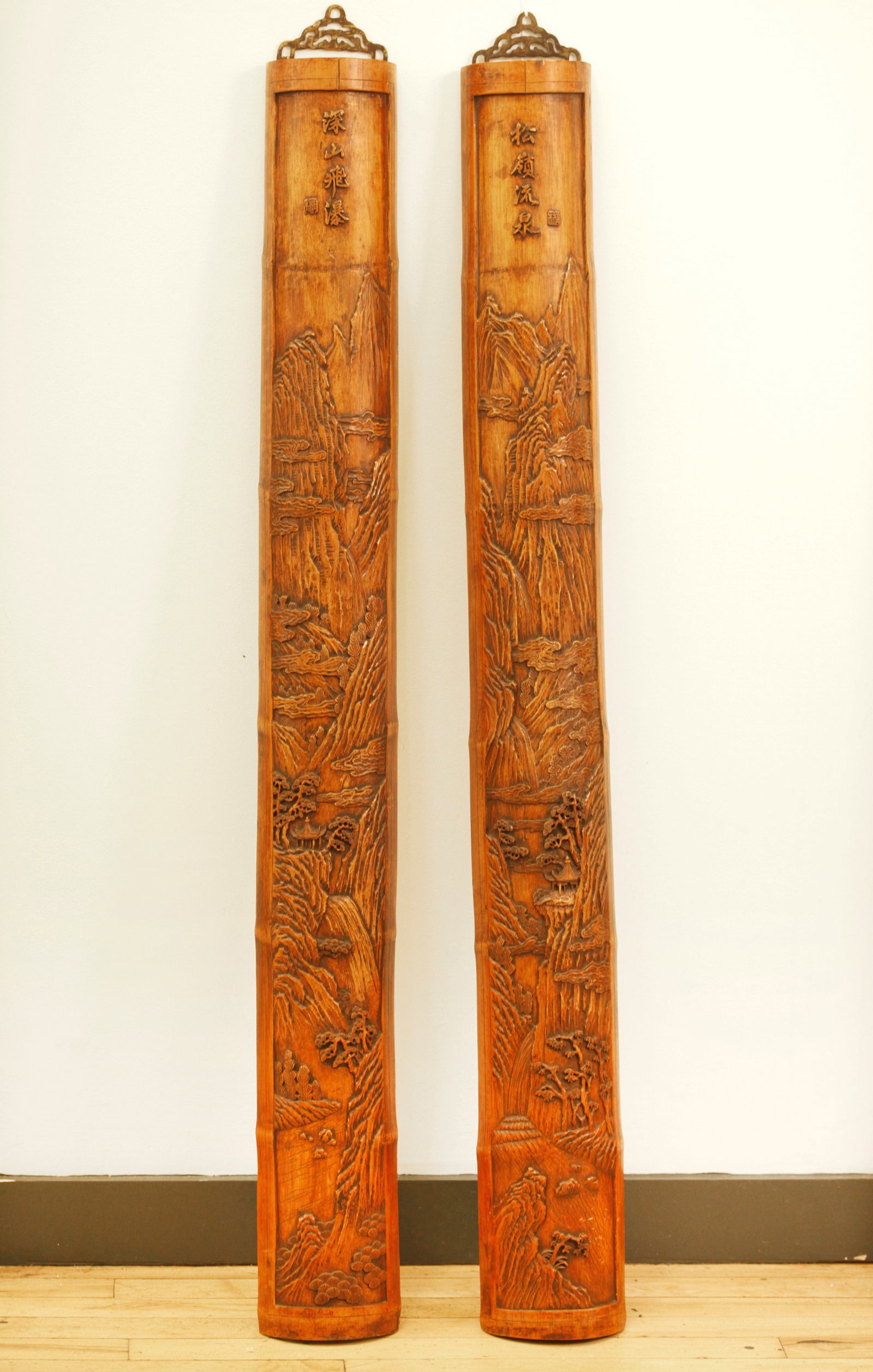 Pair Chinese Bamboo Carved Split Lengths: Pair Chinese Bamboo Carved Split Lengths, the outside surfaces carved in relief with Mountain, Waterfall and Pavilions in mirror Landscapes, the tops with calligraphy each with a small carved seal; wi
