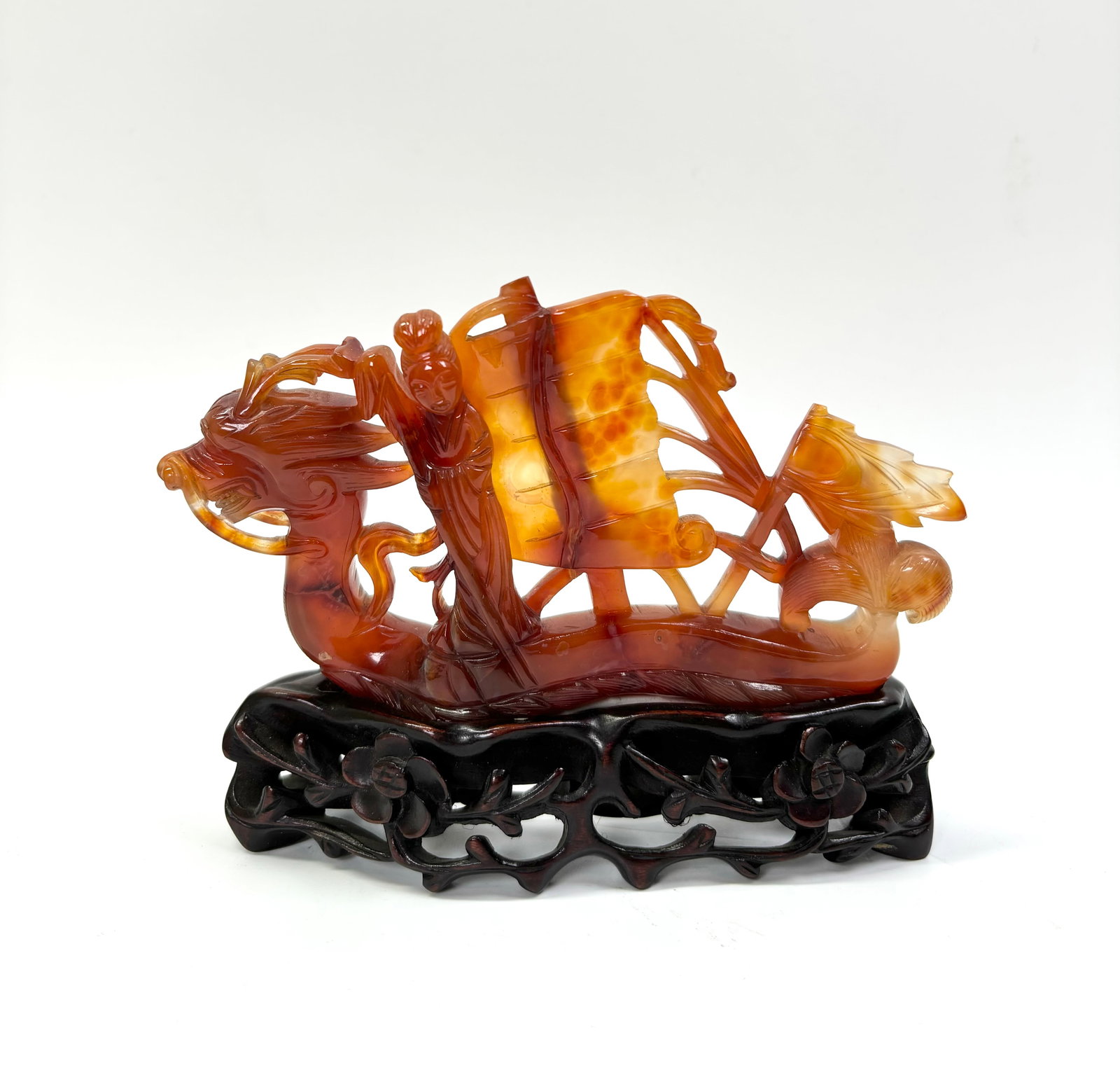 Chinese Carved Carnelian Agate Dragon Boat: *To Be Sold Without Reserve*; Chinese Carved, Pierced and Polished Carnelian Agate Dragon Boat steered by a Lady Immortal with Sail, Rigging and Flag, a Dragon Bow and Tail Stern with water waves alon