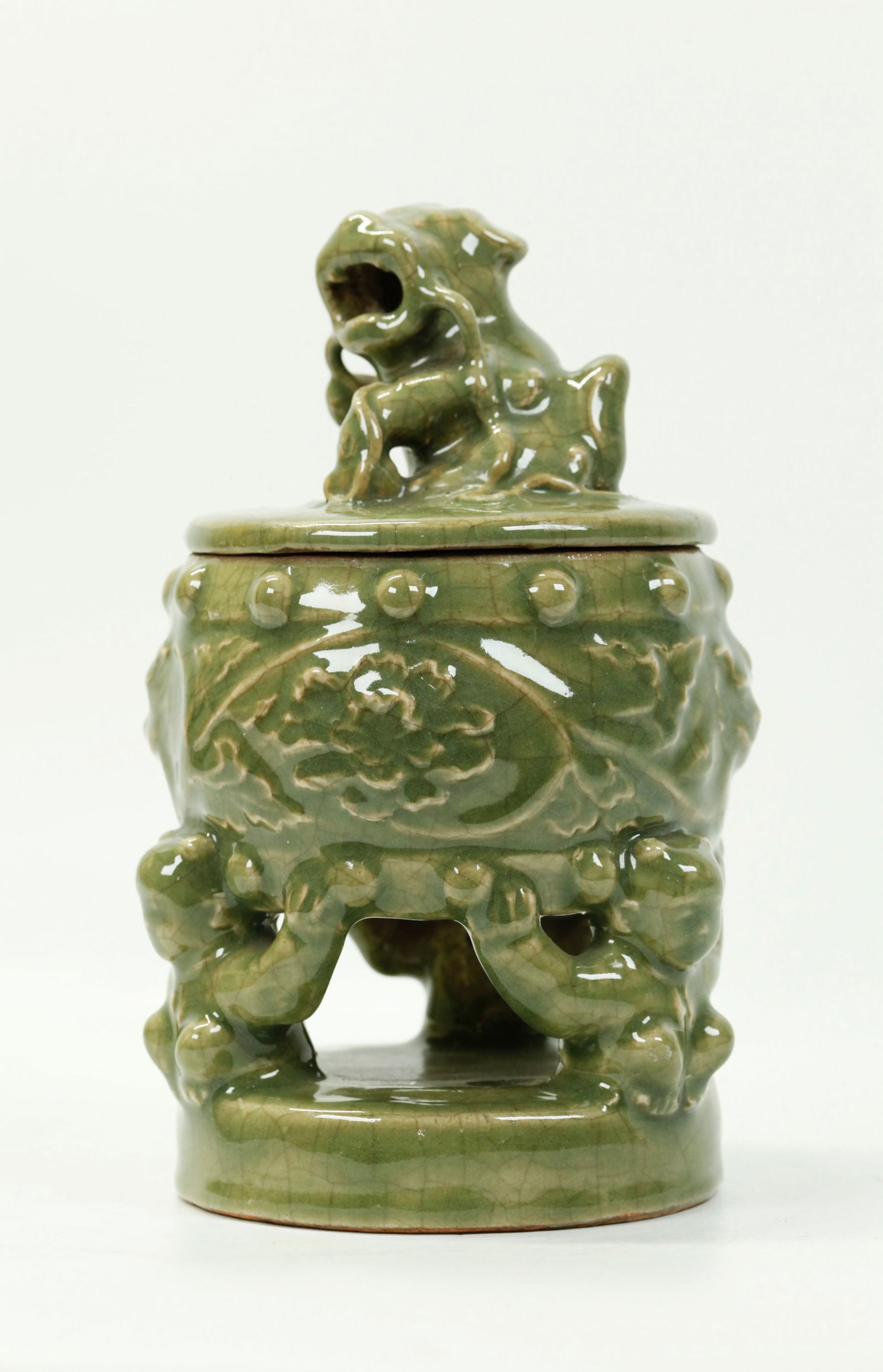 Japanese Celadon Crackle Porcelain Incense Burner: Japanese Celadon Crackle Porcelain Incense Burner formed as a Drum held up by 3 Boy feet on a round base, the cover with a Shishi Dog opened from the inside to the mouth for escaping incense. Height w