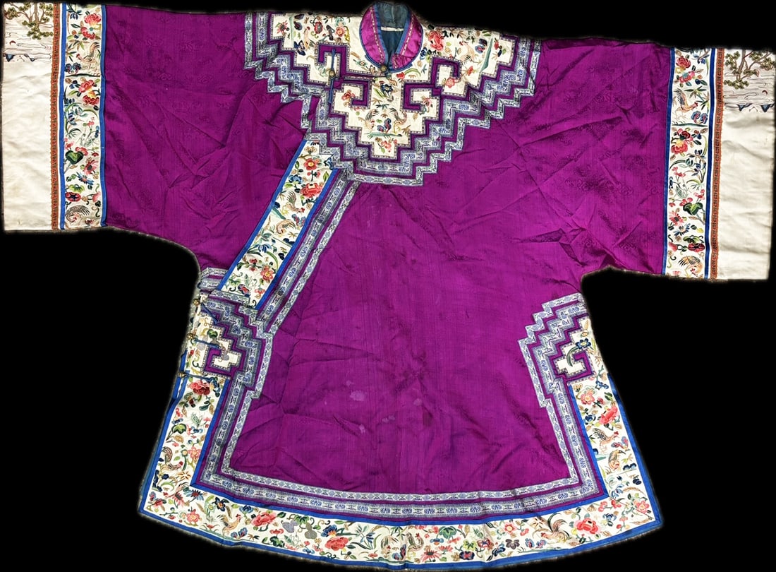 Chinese Purple Ground Embroidered Silk Lady Robe: A Chinese Embroidered Silk Ladies' Robe, 19th Century. the purple ground bordered with embroidered ribbons of along the collar, hem and side openings, the cuffs having similar decoration. Height 39 in