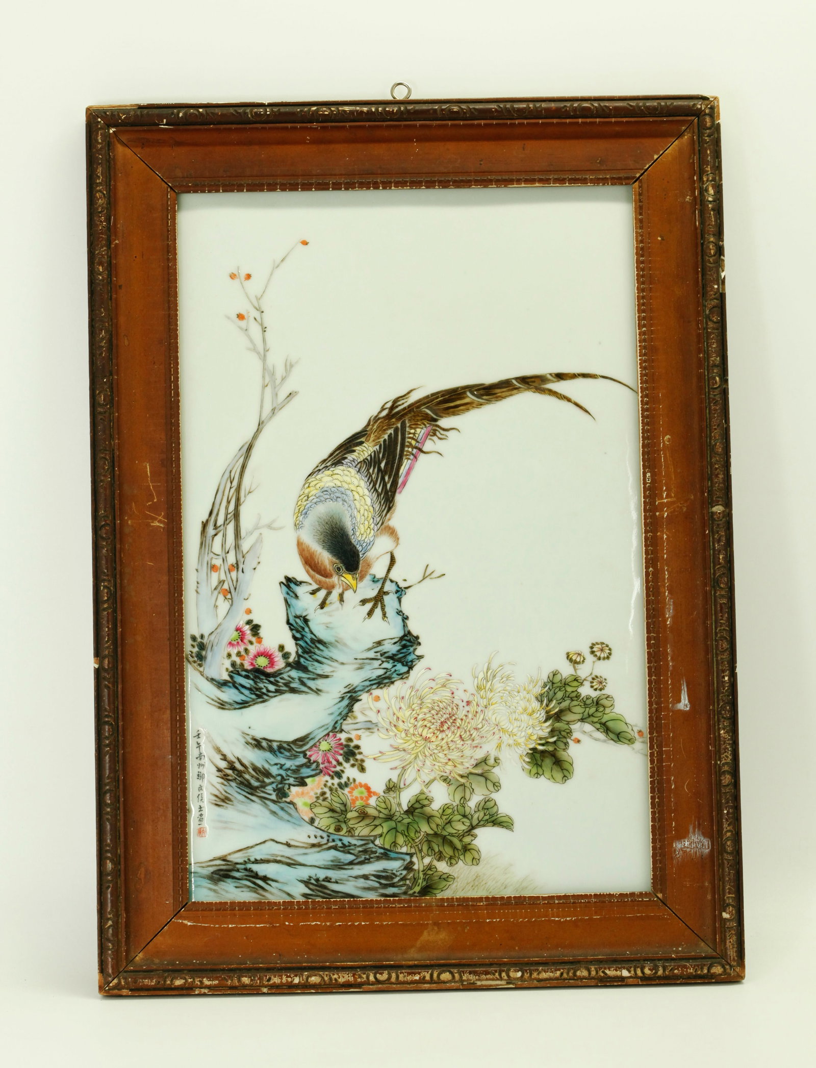 Zou Wenhou; Chinese Porcelain Pheasant Plaque: Zou Wenhou; Chinese Famille Rose Enameled Porcelain Plaque of a Pheasant on a Garden Rock surrounded by Flowers with a vertical inscription to lower left with small red seal; framed. Height of porcela