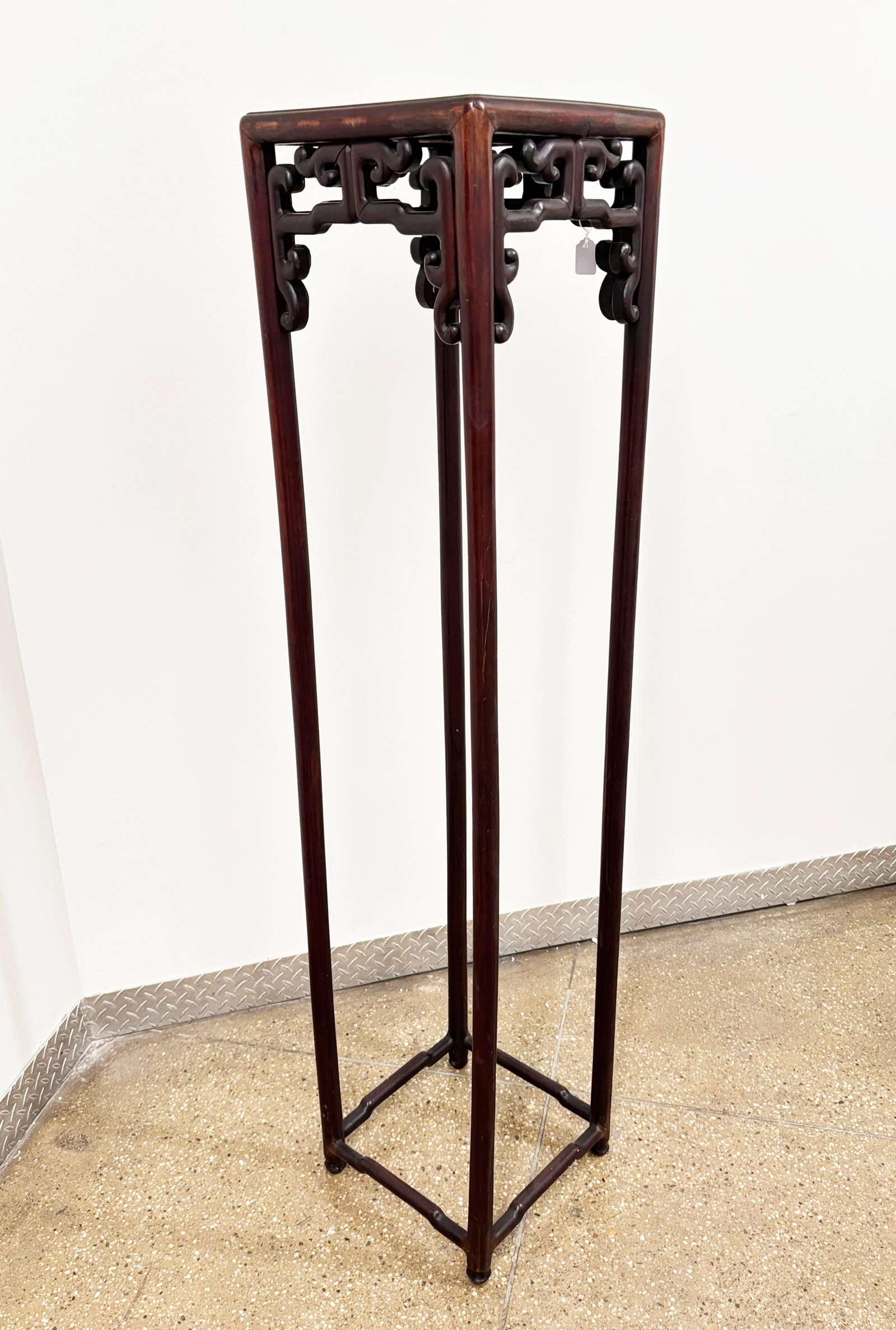 Tall Chinese Hard Wood Square Stand: Tall Chinese Square Hard Wood Stand on 4 rounded tubular legs with cross braces near base and with connecting brackets under the top; the top with slightly raised edges to 4 sides. Height 61 1/4 inche