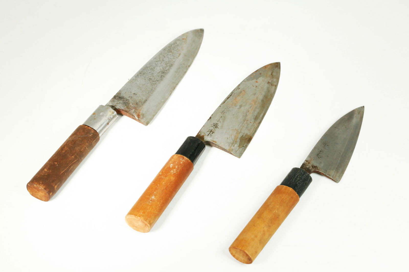 3 Japanese Hand Forged Steele Knives Wood Handles: 3 Japanese Hand Forged Steele Knives with Wood Handles, the largest with stamped marks to both sides, the 2 smaller with incised calligraphy marks to 1 side each. Length of largest 11 3/4 inches.