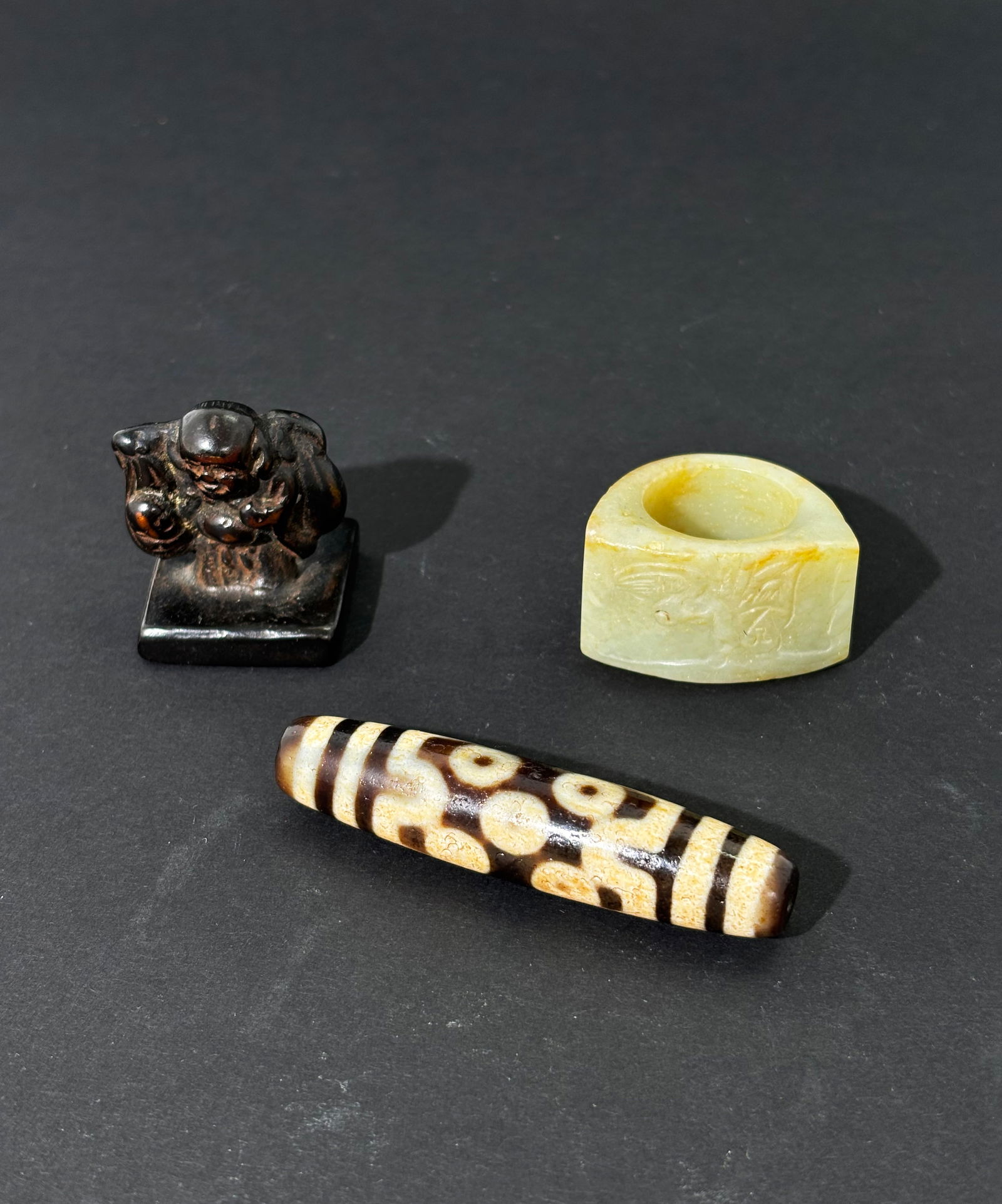 Lg Tibetan Dzi Bead; Chinese Jade Ring Metal Seal: Large Tibetan Dzi Bead; Chinese pale celadon Jade Ring carved with Figure & Bird; together with a Bronzed Metal Seal with Budai Buddha finial and the face molded with reverse calligraphy. Length of Dz