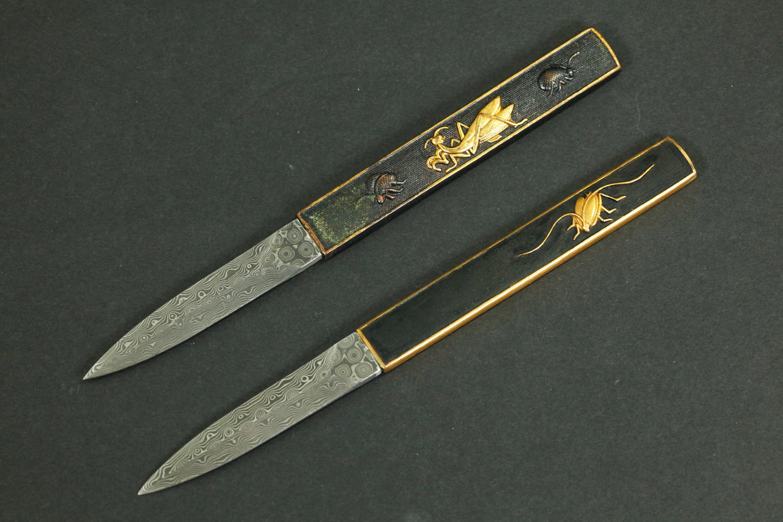2 Japanese Gilt Bronze Kozuka Handles; Iron Knives: 2 Japanese Gilt Bronze Kozuka Handles each with gilt bug designs,now fitted with Damascus patterned Iron Knives, pointed but with blunt edges. Length 6 1/2 inches.