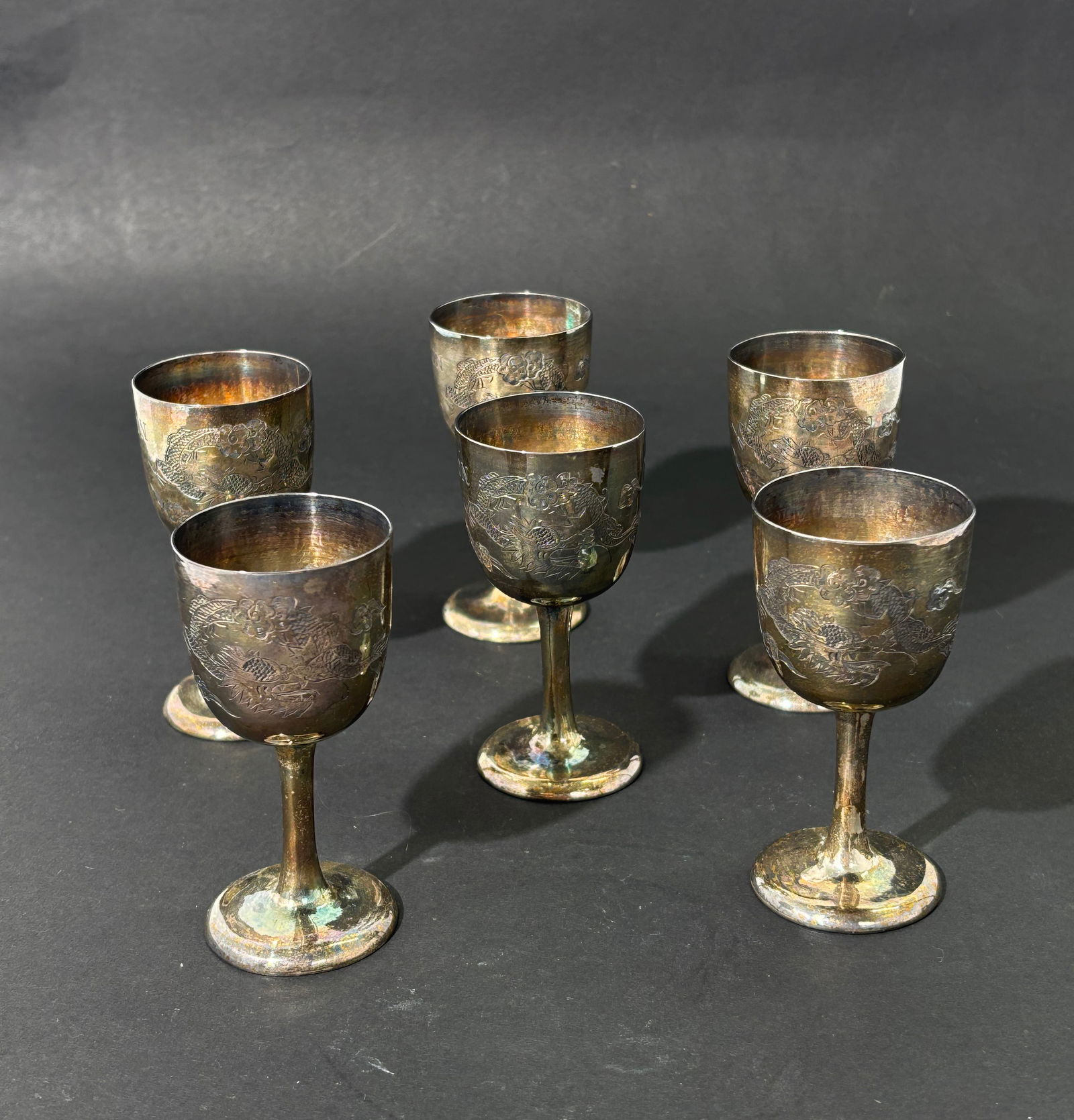 Wu Hua; 6 Beijing Chinese Engraved Wine Stem Cups: 6 Chinese Silver Wine Stem Cups; Mark of WU HUA, Bejing, circa 1890-1940; each incised with a coiled Dragon, 3 with "TO MOTHER FROM SON / PEIPING CHINA" and 3 with "TO DAD FROM SON / PEIPING CHINA." E