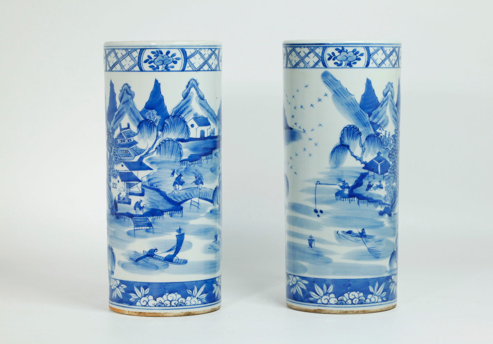 Pr Chinese Qing Blue & White Porcelain Hat Stands: Pair Chinese Qing Dynasty Blue & White Porcelain Hat Stands (tubular vases) each with a landscape scene of figures including the 4 Noble Professions, houses, boats and mountains; the recessed bases in
