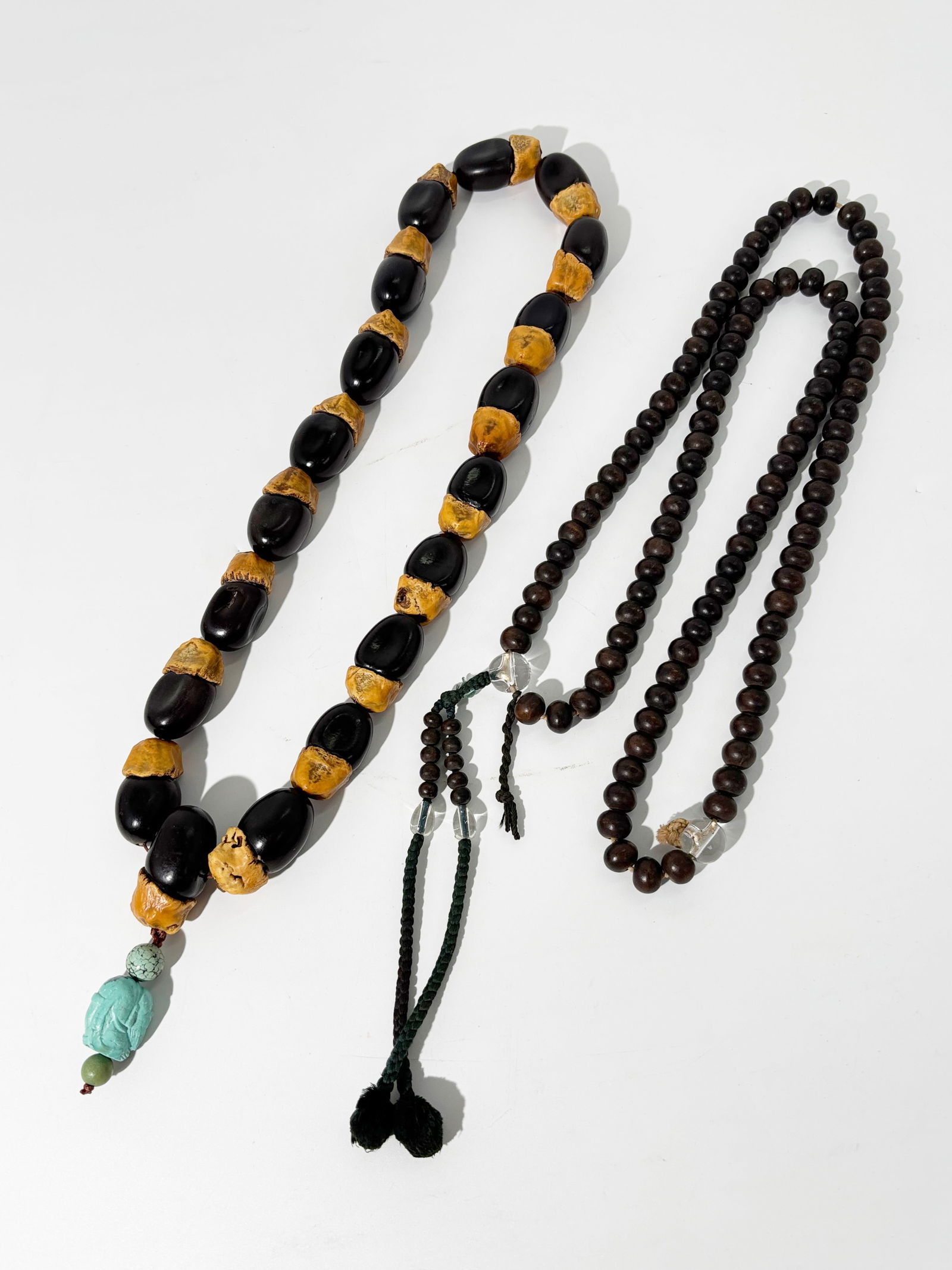 2 Chinese Buddhist Prayer Necklaces: Seeds & Wood: 2 Chinese Buddhist Prayer Necklaces or rosaries: an 18 large Nut Shell necklace with additional shell as head-bead with carved turquoise "Lohan" pendant; together with a small round Wood 108 bead rosa