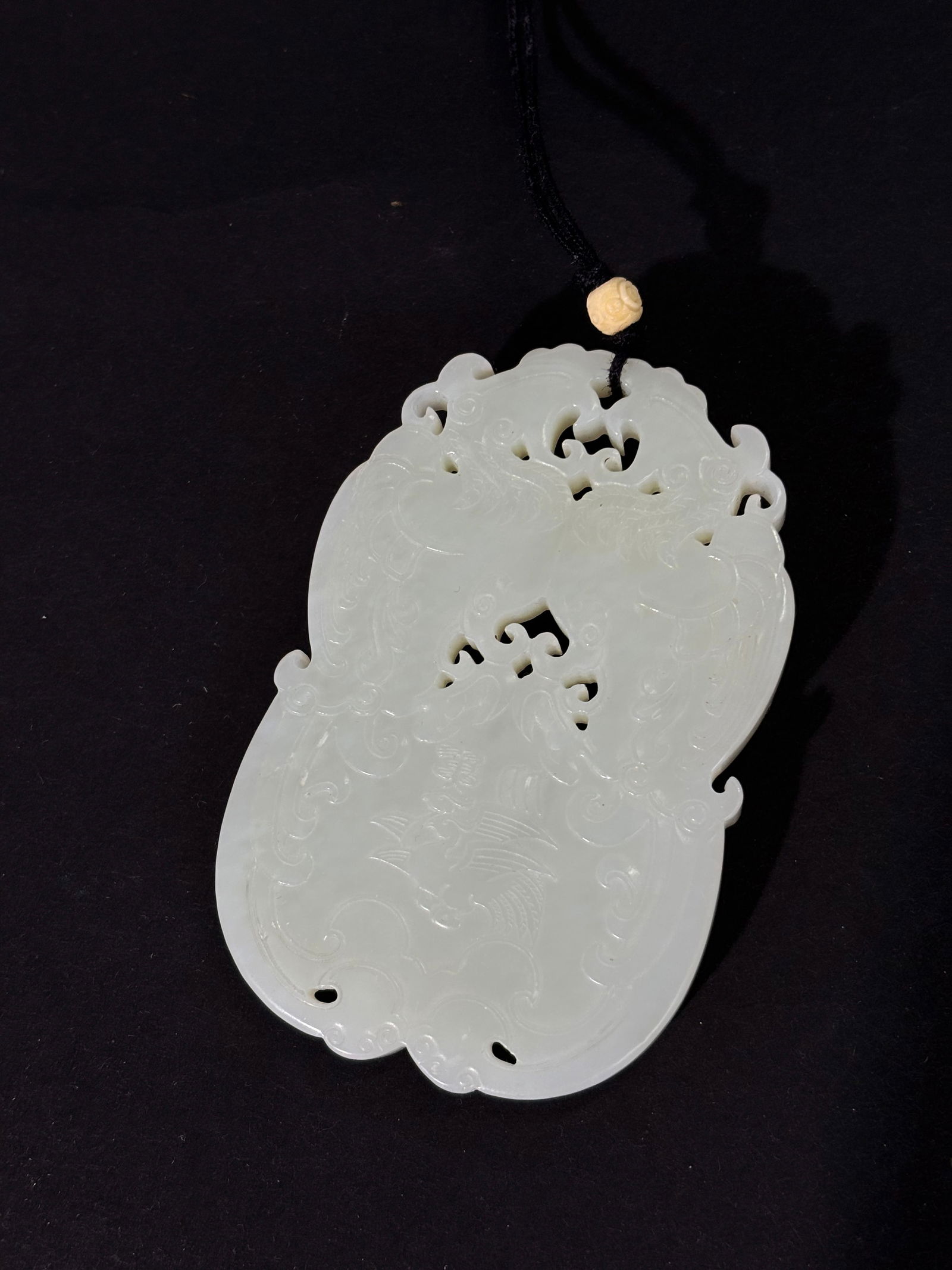 Large Chinese White Jade Double Phoenix Pendant: Large Chinese White Jade confronting Double Phoenix Pendant with a hole between their combs for suspension and 2 further, smaller flying birds with calligraphy between the tail feathers; the design re