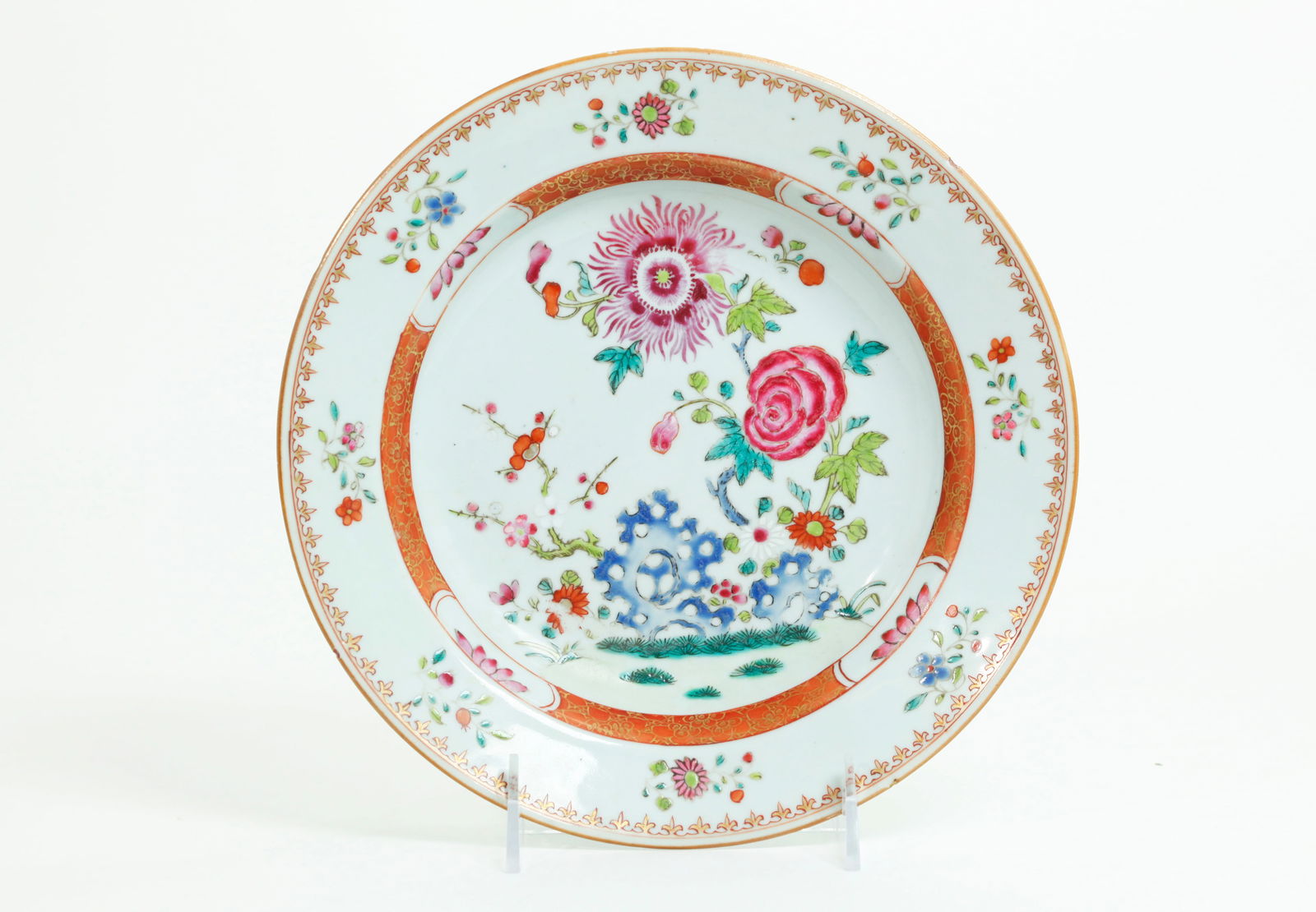 Chinese 18th C Famille Rose Porcelain Floral Plate: Chinese 18th Century Famille Rose Porcelain Plate or low bowl with a center of exotic flowers behind a blue garden rock, the edge with 8 sprigs of flowers between iron red & gilt borders; the reverse