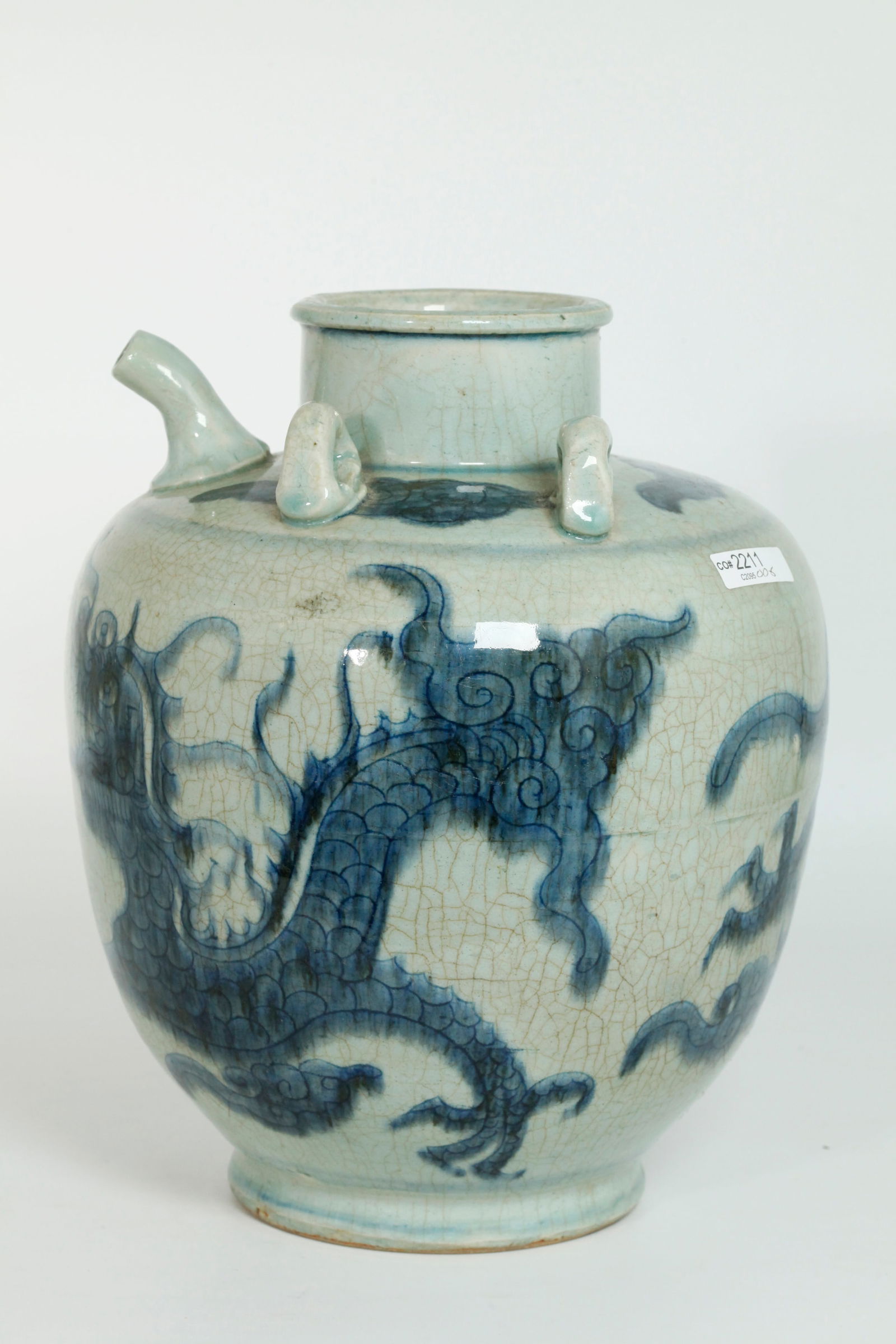 Lg South East Asian Blue & White Porcelain Pitcher: Large South East Asian Blue & White crackle Porcelain Pitcher with spout and hand-grip mouth & foot ring with 2 pairs of loops for handles not present, the body incised with a 4-claw Dragon and Flamin