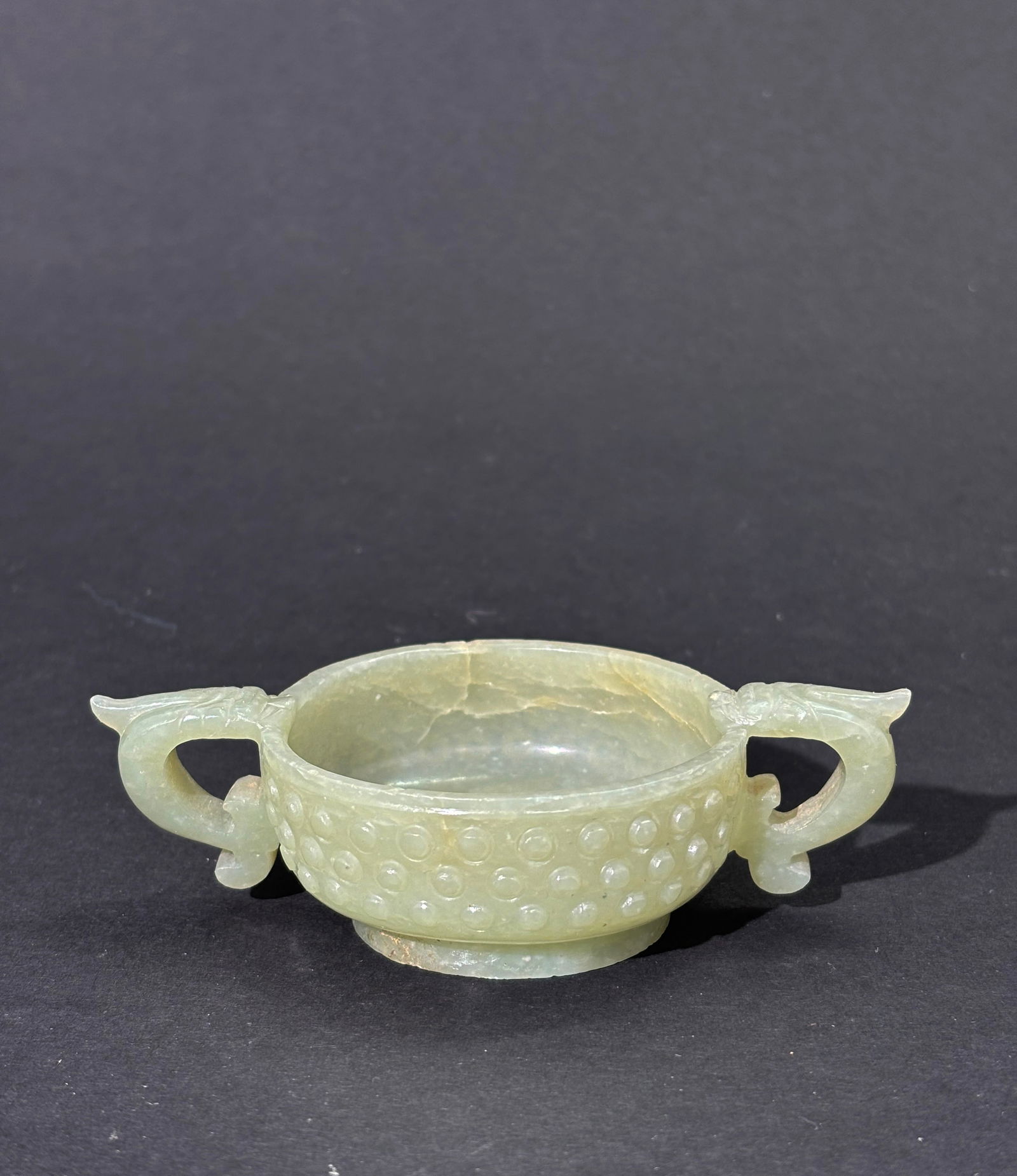 Chinese Ming Celadon Jade Cup Dragon Handles: Chinese Ming Dynasty Light Celadon Jade Cup with 3 rows of bosses carved and polished to the sides, with 2 single horn Dragon-Head & Fish Tail Handles and a channeled foot ring around slightly convex