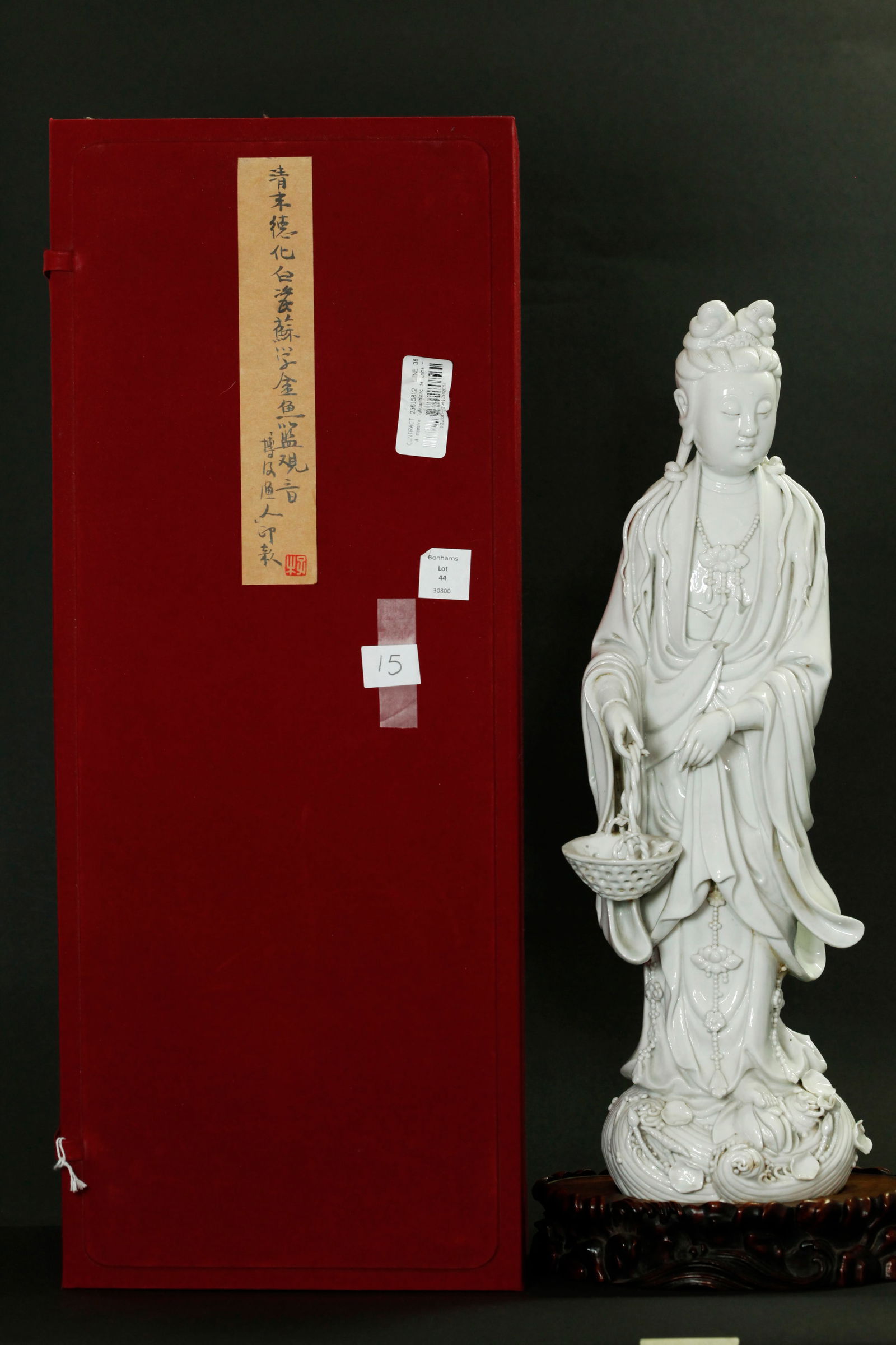 Bo Ji Yu Ren; Large Chinese Blanc De Chine Guanyin: Large Chinese 19th or early 20th Century Blanc De Chine Dehua Porcelain Guanyin standing on Lotus Blossom with Lotus Leaves in swirling waves, holding a basket with a Carp, with "Lotus" jewels and fin