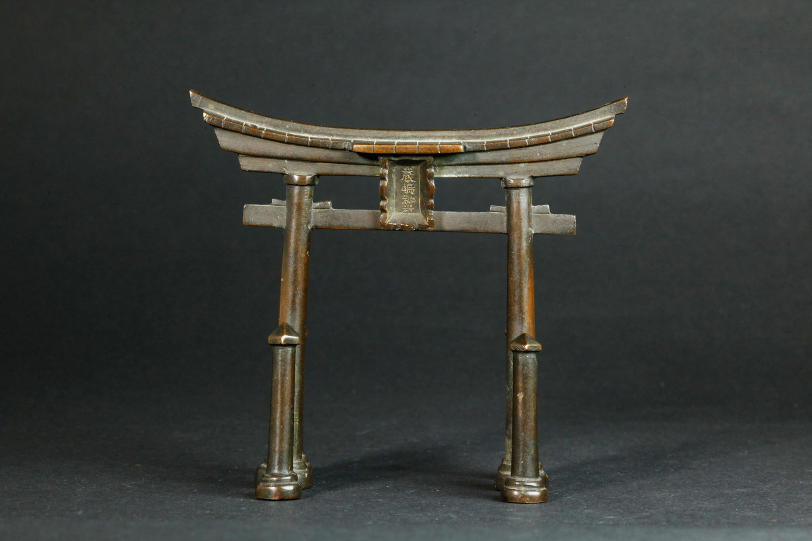 Japanese Copper Fushimi Inari Torii Shrine Gate: Japanese miniature Copper Fushimi Inari Torii Shrine Gate with calligraphy plaque to top center and a seal mark to base of 1 of the 6 feet. Height 4 1/4 inches X width 4 3/4 inches. PROVENANCE: From t