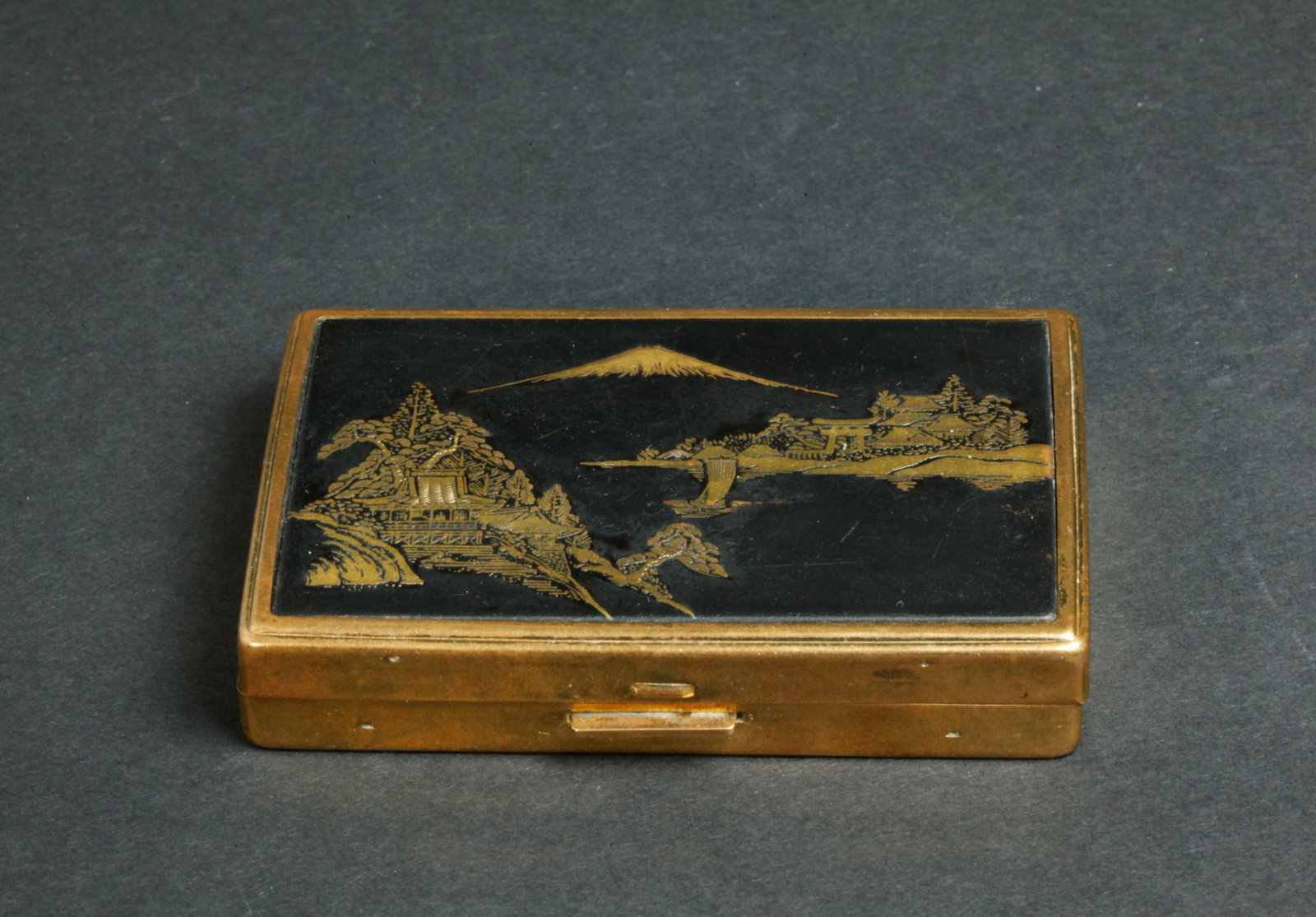 Vintage 1950's Clover Brand Face Powder Music Box: Vintage 1950's Clover Brand Face Powder hinged compact with imitation Japanese Mount Fuji Scene etched with a black background; the inside with hinged face powder compartment labeled "Clover" to each,