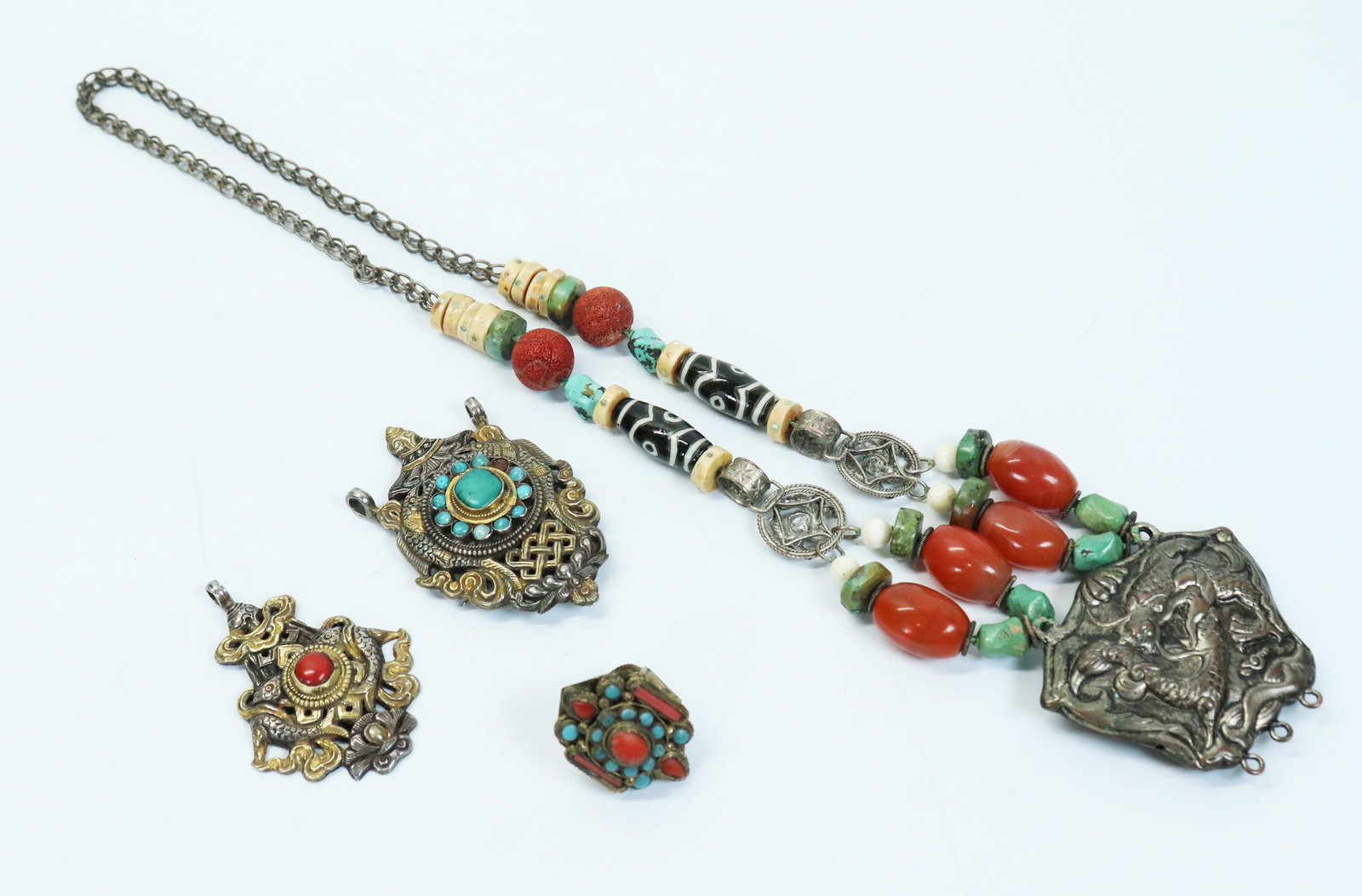 4 Pc Tibetan Silver: Necklace 2 Pendants 1 Ring: 4 Vintage Pieces Tibetan Silver and Silvered Jewels: 1 Bead & Chain necklace with 2 Dzi-type Beads, 4 Carnelian Beads, turquoise, etc; 2 Tibetan Silver and Silver Gilt Pendants, 1 set with a Coral Cab
