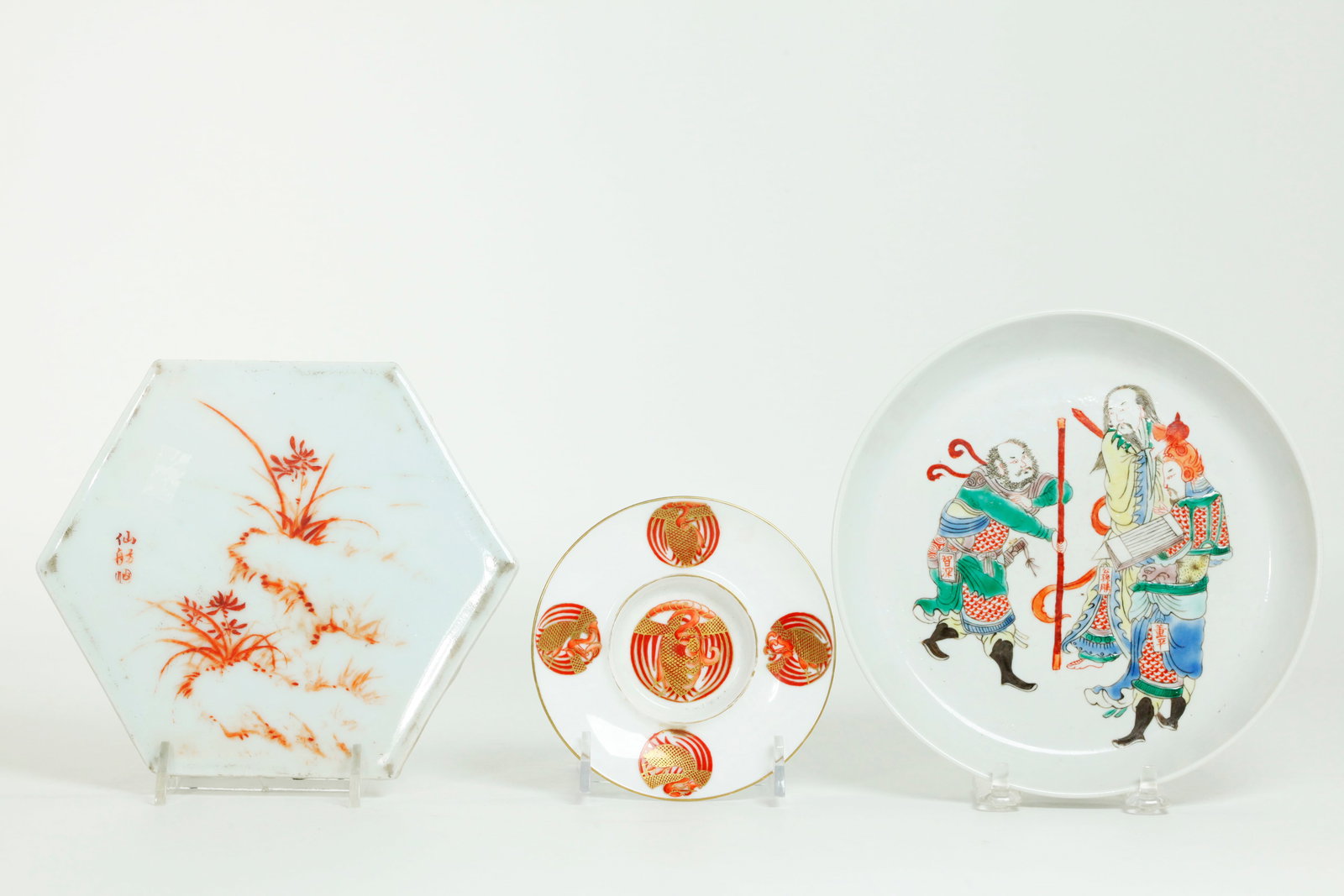 3 Chinese Porcelains: Low Bowl Cup Stand Plaque: 3 Chinese Porcelains: a Low Bowl decorated in Famille Verte enamels with 2 Military Generals and a barefoot Scholar each with small calligraphy tab, the reverse in clear glaze; a Cup Stand decorated w