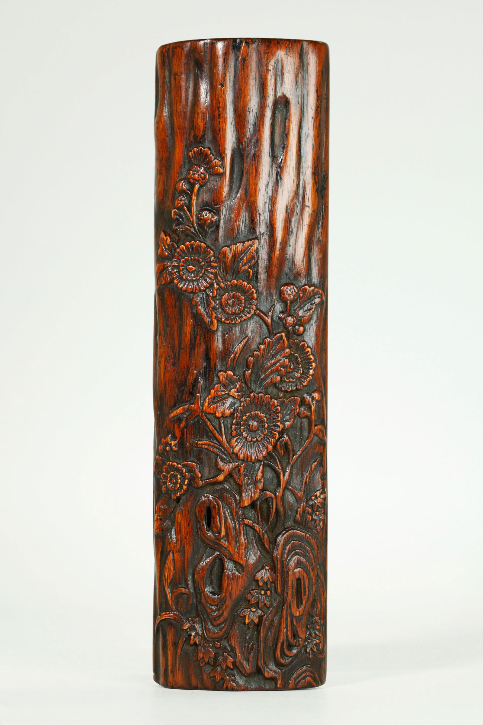 Chinese Chenxiang Wood Calligraphy Wrist Rest: Chinese Chenxiang Wood Calligraphy Wrist Rest carved to the arched top with stems, leaves and chrysanthemum flowers rising from a Garden Rock and on a textured ground, the reverse with polish. Length
