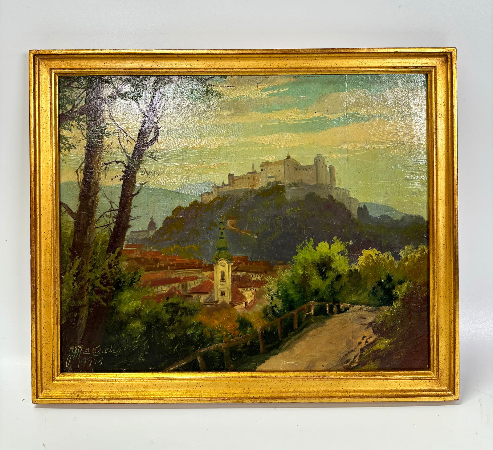 Eastern European Oil Sketch Mountain Castle: Eastern European Oil Sketch on wood board of a Mountain Castle with Town below; signed and dated indistinctly lower left corner; good gold leaf frame. Height of frame 10 5/8 inches X width of frame 12