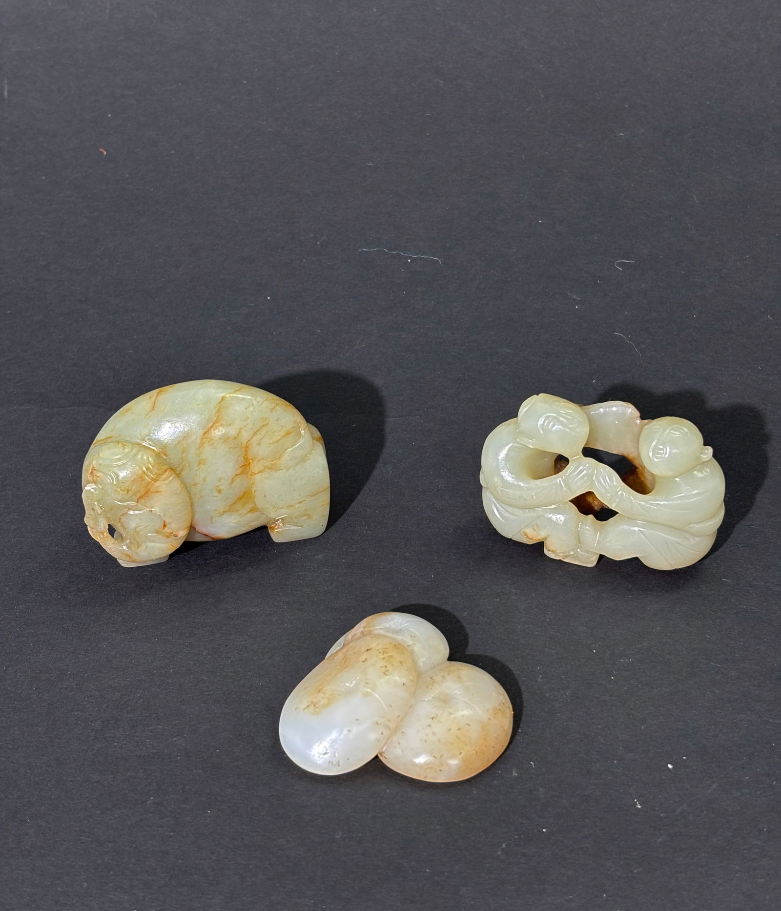 3 Chinese Qing Jades; Elephant 2 Boys 3 Mushrooms: 3 Chinese Qing Dynasty Jades; a celadon standing Elephant with russet lines, pale celadon to brown jade 2 Boys playing with feet and arms joined to form a scarf slide; together with a 3 Mushrooms pend