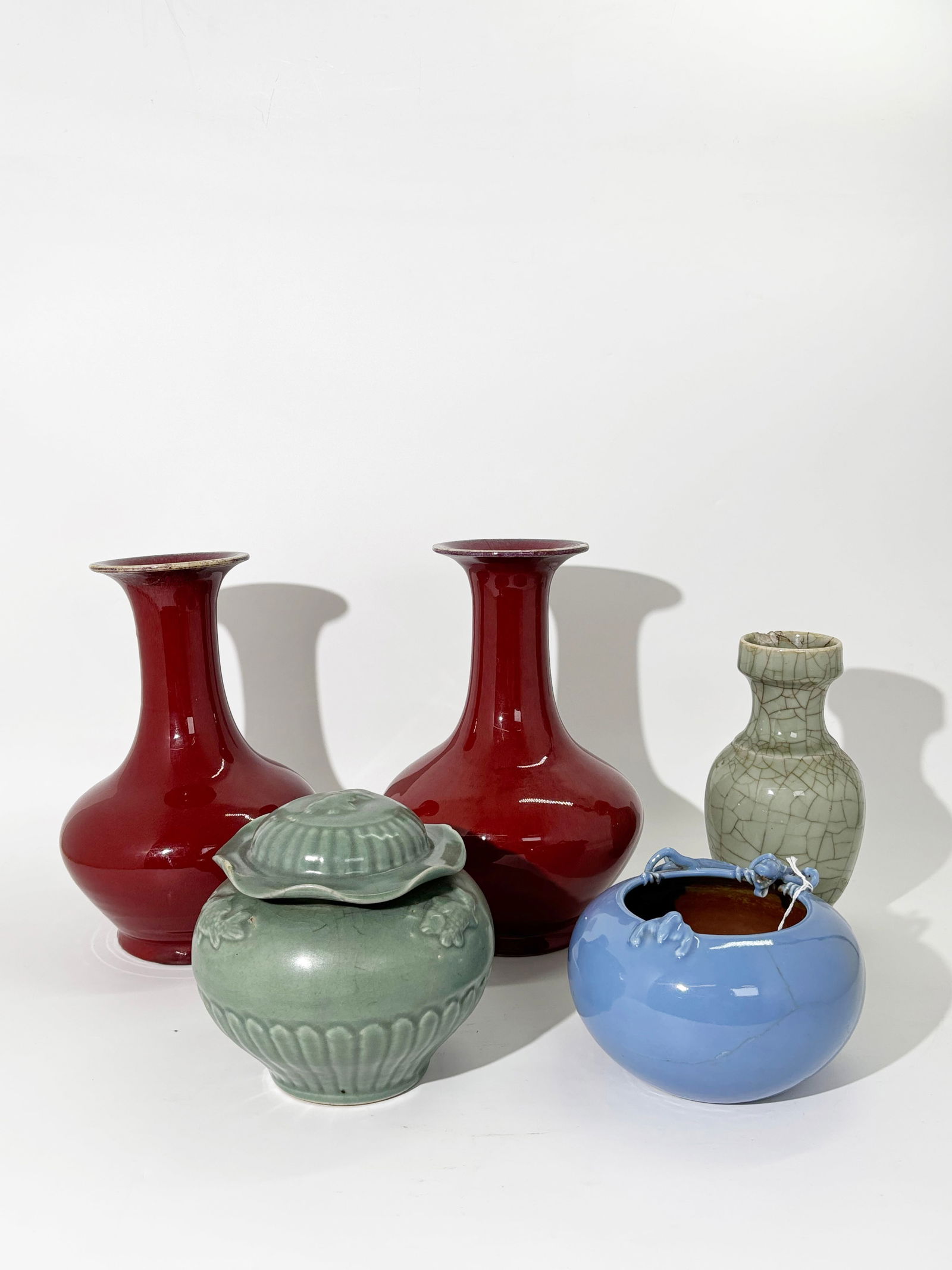 Pr Chinese Red Crackle Vase, 3 Celadon Porcelain: Pair Chinese 19th Century Underglaze Red Crackle Porcelain Vases with slight flambe at the flared neck thinning to pale celadon at the mouth edge, with glaze over-flow to unglazed foot ring and base.