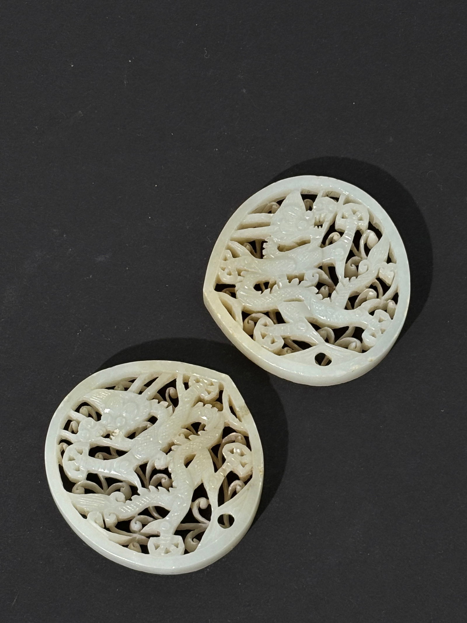 Pr Chinese Ming White Jade Dragon Belt Plaques: Fine Opposing Pair Chinese Ming Dynasty White Jade 4-claw Dragon Belt Plaques in Lotus-petal shape; carved, pierced and polished on 2 levels with the backs plain. Height 2 1/8 inches X width 2 1/4 inc