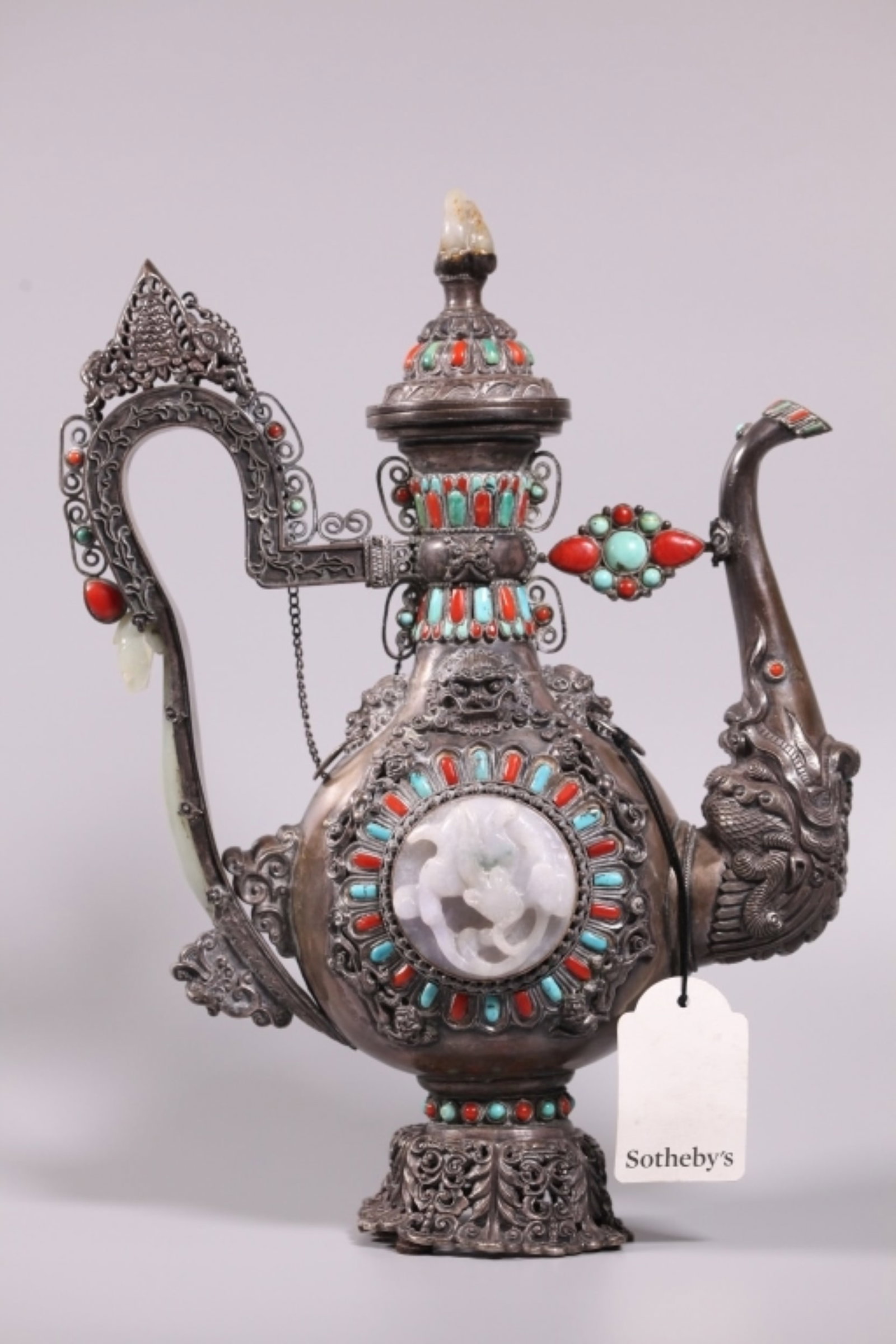 Sotheby's London; Mongolian Style Silver Ewer: Mongolian Style Silver Ewer with round Jadeite Dragon plaques to sides, a jade belt hook forming part of handle and a small jade toggle as a cover finial with alternating turquoise and coral shaped ca