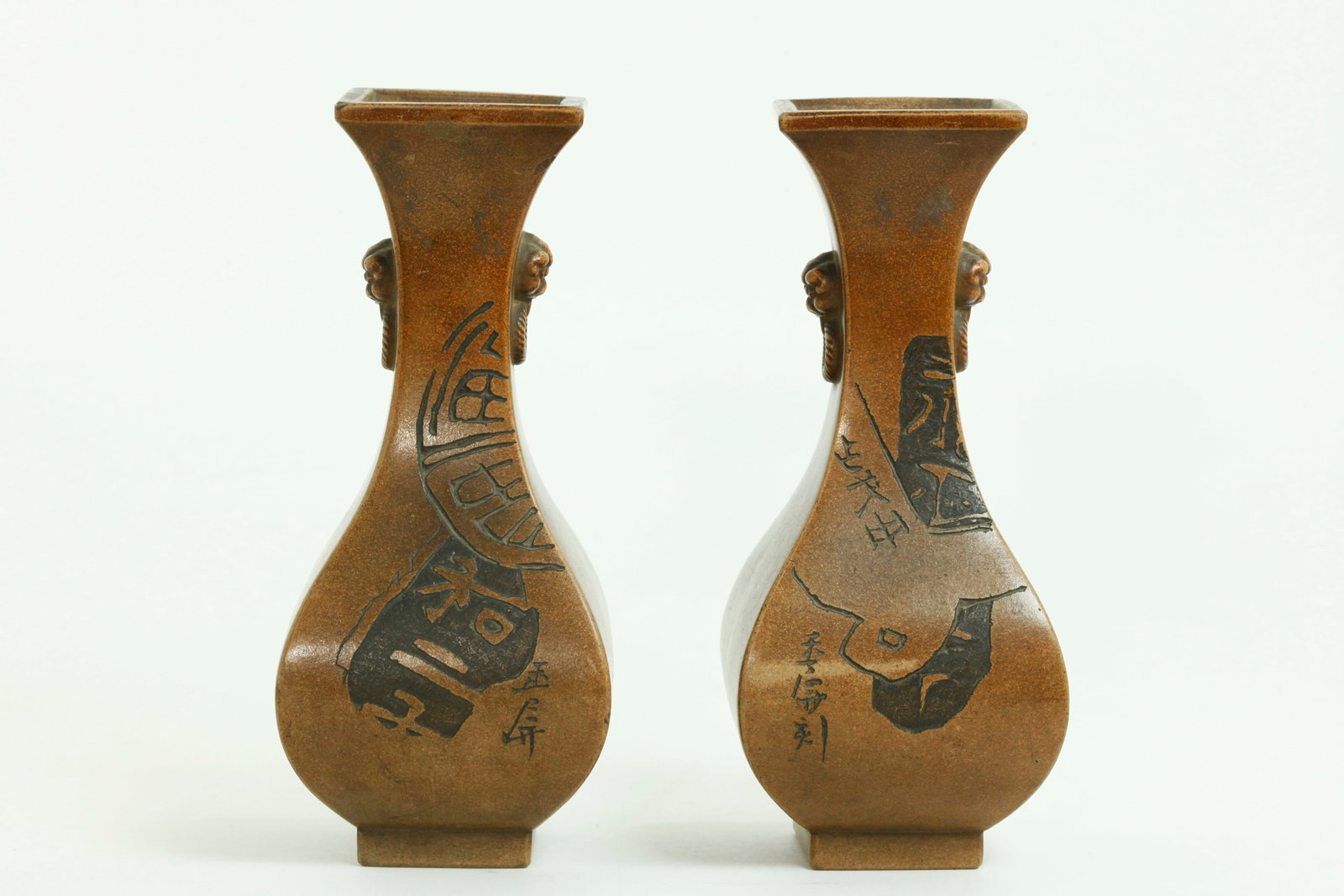 Rare Pr Chinese Light Clay Yixing Zisha Vases: Rare Pair Chinese Light Clay Yixing Zisha 4 sided Vases, each with pairs of molded animal head & twisted ring handles to the neck, the front panels with an incised design of ancient coin calligraphy w
