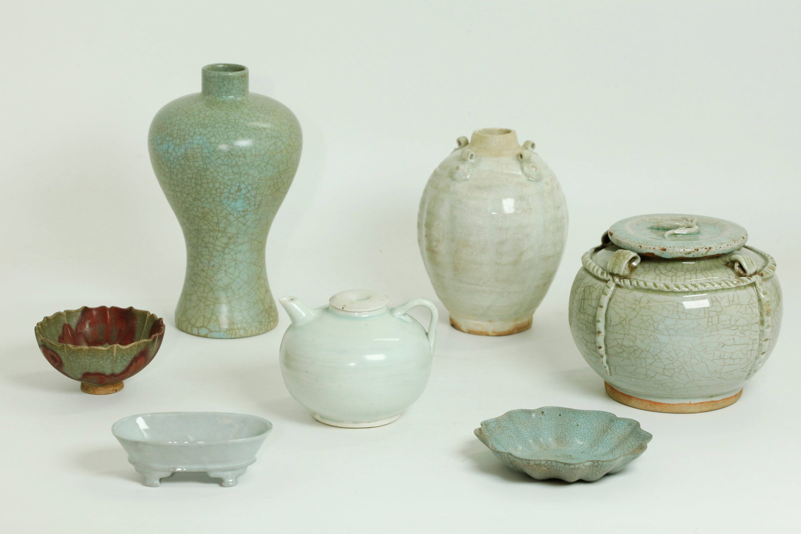 3 Chinese Celadon, 3 Guanyao crackle, 1 Junyao: 3 Chinese White / Pale Celadon Porcelains: a fluted jar possibly Song Dynasty, in crackle white glaze with 4 applied ring & discs at the shoulders, the base and foot ring unglazed with the mouth ungla