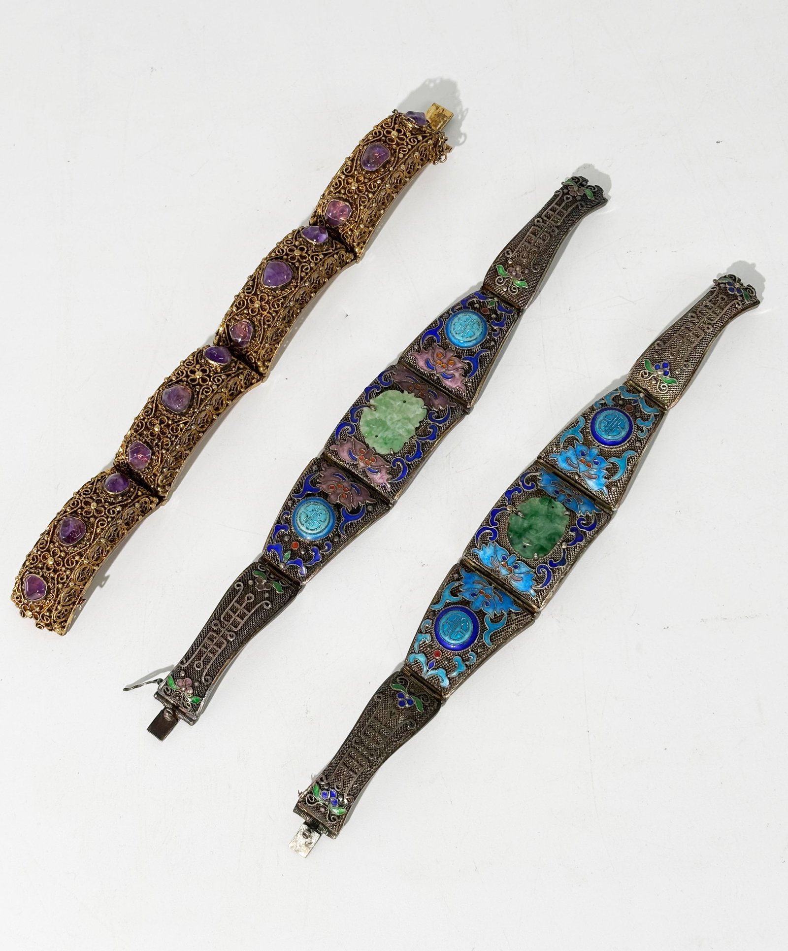 3 Chinese Qing Silver Wire-Work Hinged Bracelets: 3 Chinese late Qing Dynasty Silver Wire-Work Hinged Bracelets: 1 with gilding and small irregular cabochon amethysts with safety chain and marked "Made in China / Silver;" together with a near-pair of