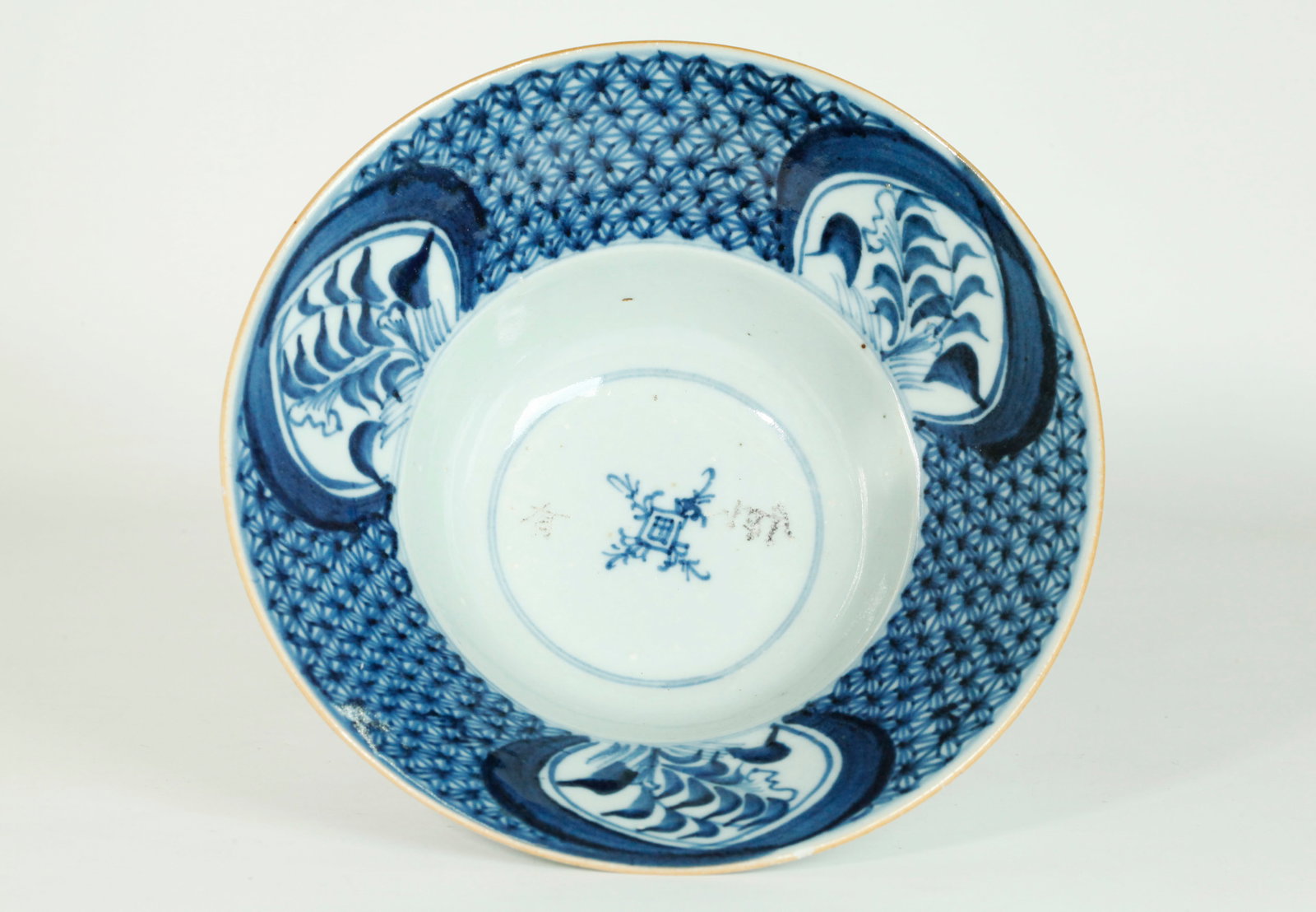 Chinese Early 18th C Blue & White Porcelain Bowl: Chinese Early 18th Century Blue & White Porcelain Bowl with wide flared mouth with brocade pattern in underglaze blue with 3 windows of flowers, the outside edge with brown slip and the recessed base