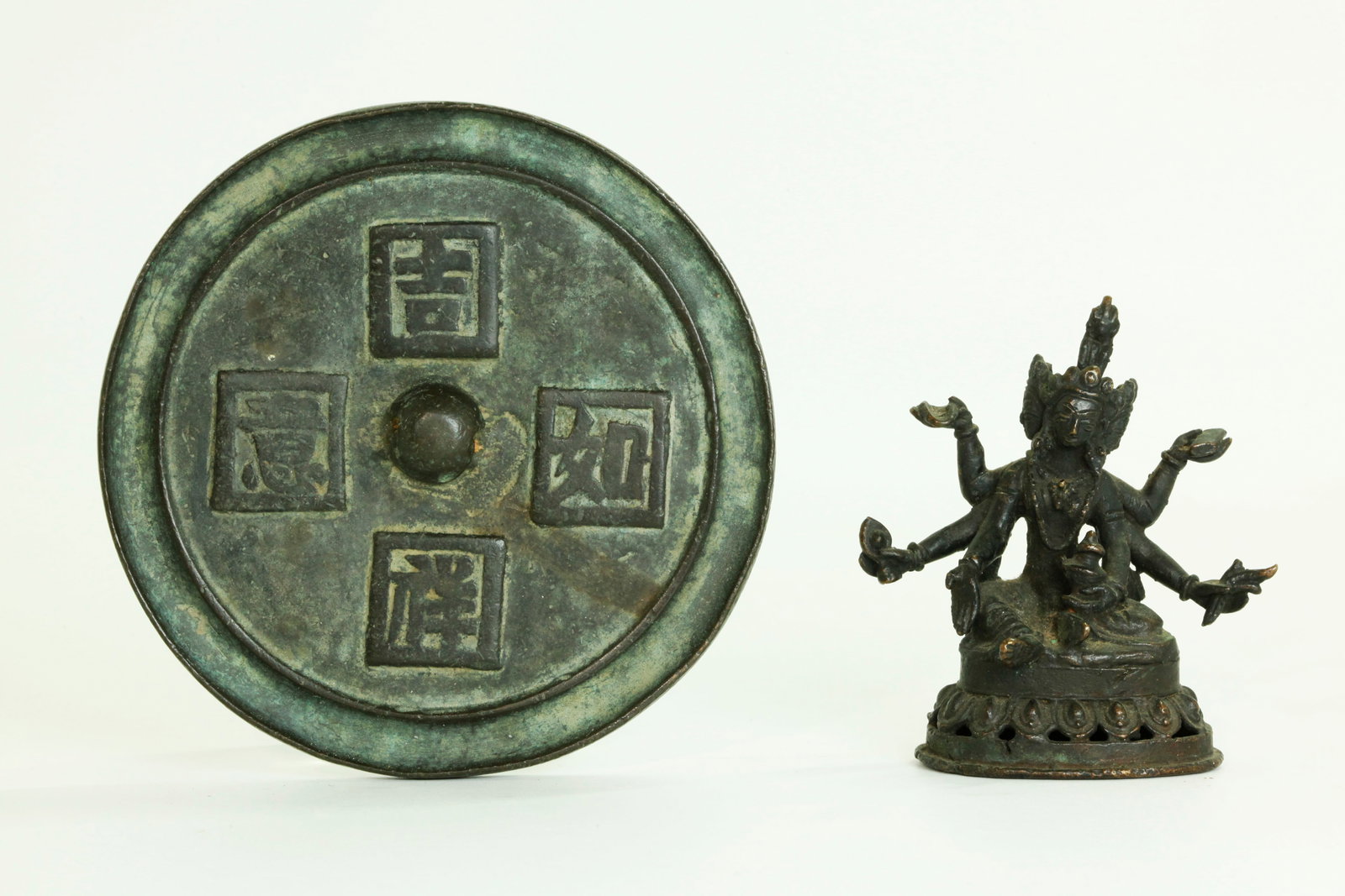 Tibetan 19th C Bronze Manjuvajra; Chinese Mirror: Tibetan 19th Century Bronze meditating Manjuvajra with 6 hands and 3 faces on a pierced lotus stand with open base; together with a Chinese Ming Dynasty round bronze Mirror cast with 4 calligraphy squ