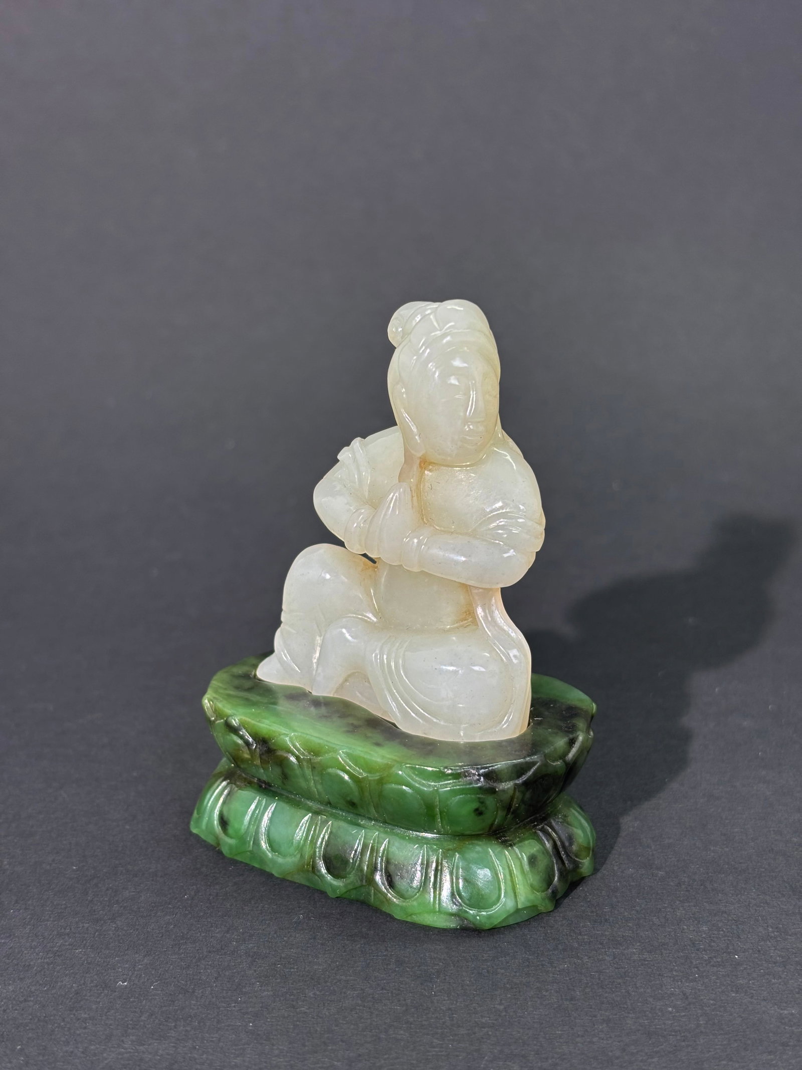 Chinese Warm White Jade Bodhisattva, Green Base: Chinese Warm White Jade seated Bodhisattva with hands in Anjali Mudra and with a carved dark Green Jade double lotus Base recessed to the shape of the figure and with a flat base. Height with green ja