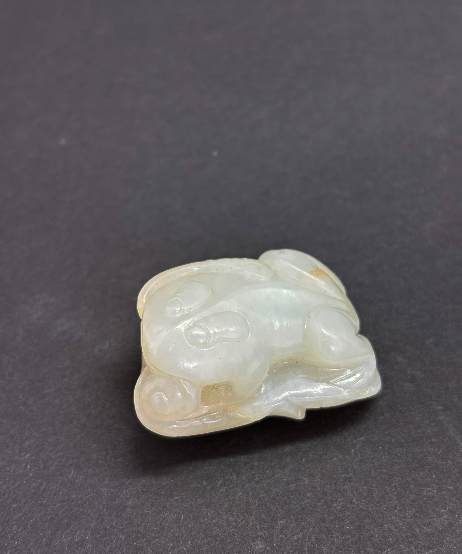 Chinese 18/19 C White Jade Frog & Lingzhi Toggle: Chinese 18th or 19th Century White Jade Frog on 2 Lotus Leaves holding a Lingzhi with a hole through 1 end for suspension as a Toggle. Height 1 inch X width 1 3/4 inches.