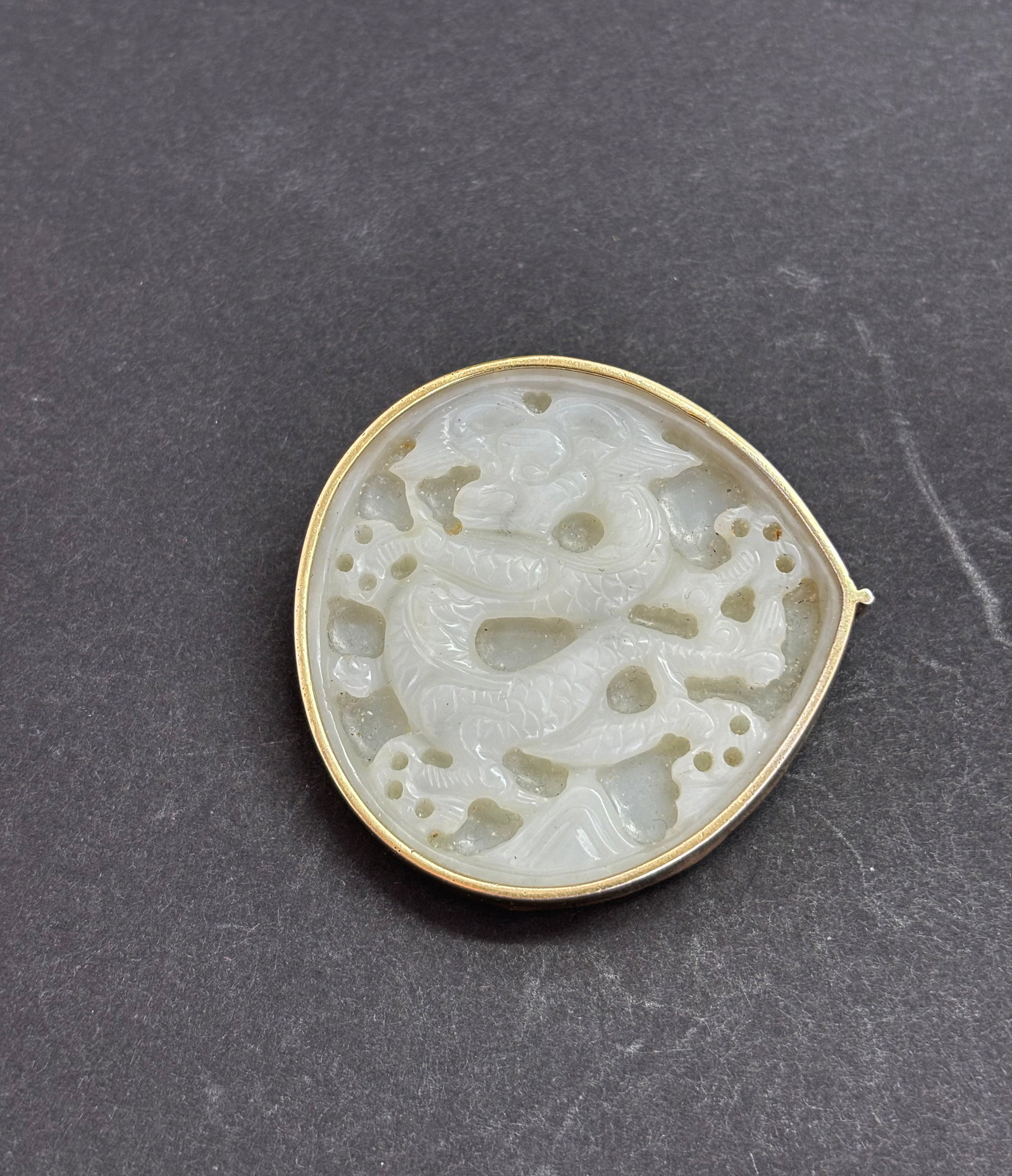 Chinese Ming White Jade Dragon Petal-Shape Plaque: Chinese Ming Dynasty White Jade Dragon Petal-Shaped Plaque, the Dragon with center-parted hair on head, with 3 pairs of bull-nose holes to the undecorated back; now framed in gilt silver with a wire h