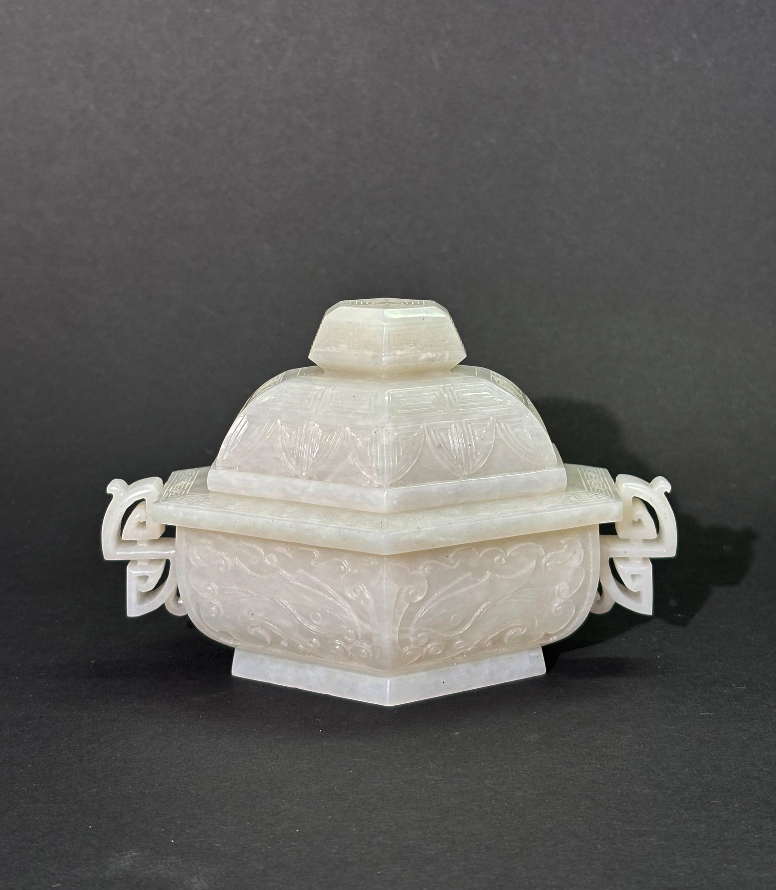 Chinese White Jade Or Jadeite Hexagonal Jar: Chinese White Jade or White Jadeite Hexagonal covered Jar, the sides carved with Taotie Masks and the short sides with "S" shaped curl handles, the recessed base with hexagonal foot and the cover with
