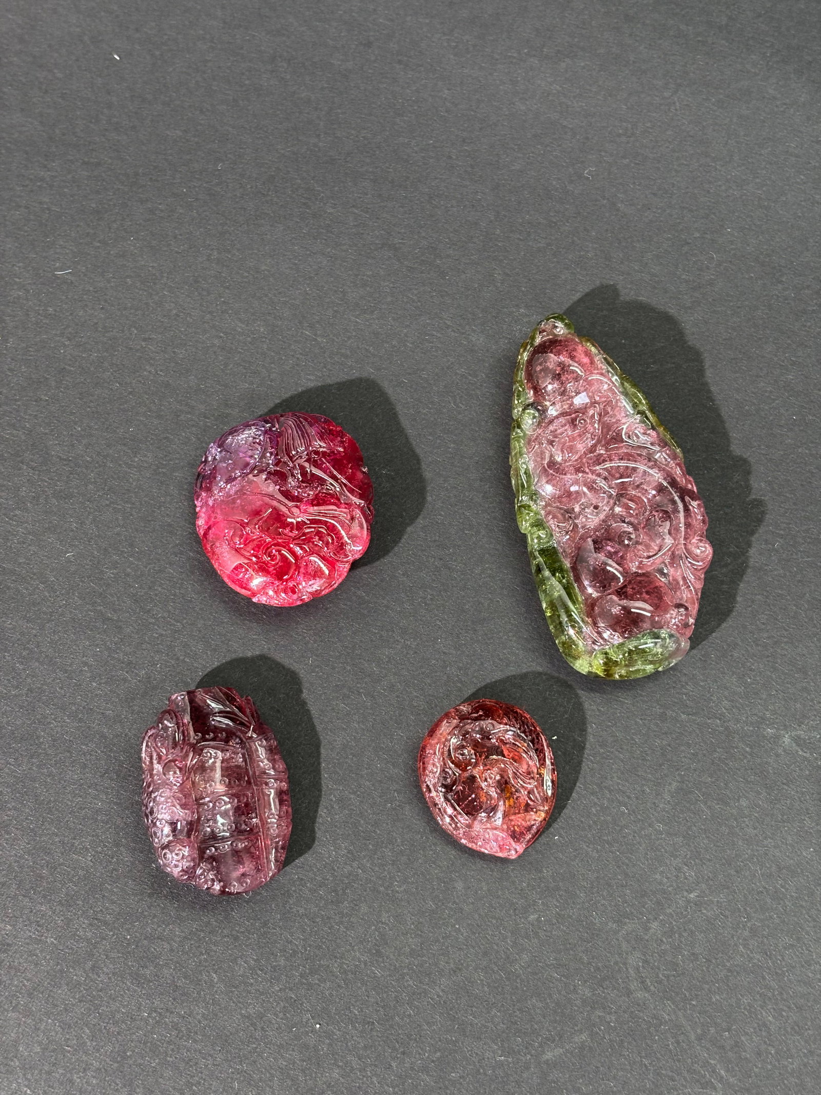 4 Chinese Carved & Polished Tourmaline Pendants: 4 Chinese Carved & Polished Tourmaline Pendants: the largest in "watermelon" with a dark pink center and green at edges well carved with a large or small Chilong Dragon to each side with Lingzhi to pi